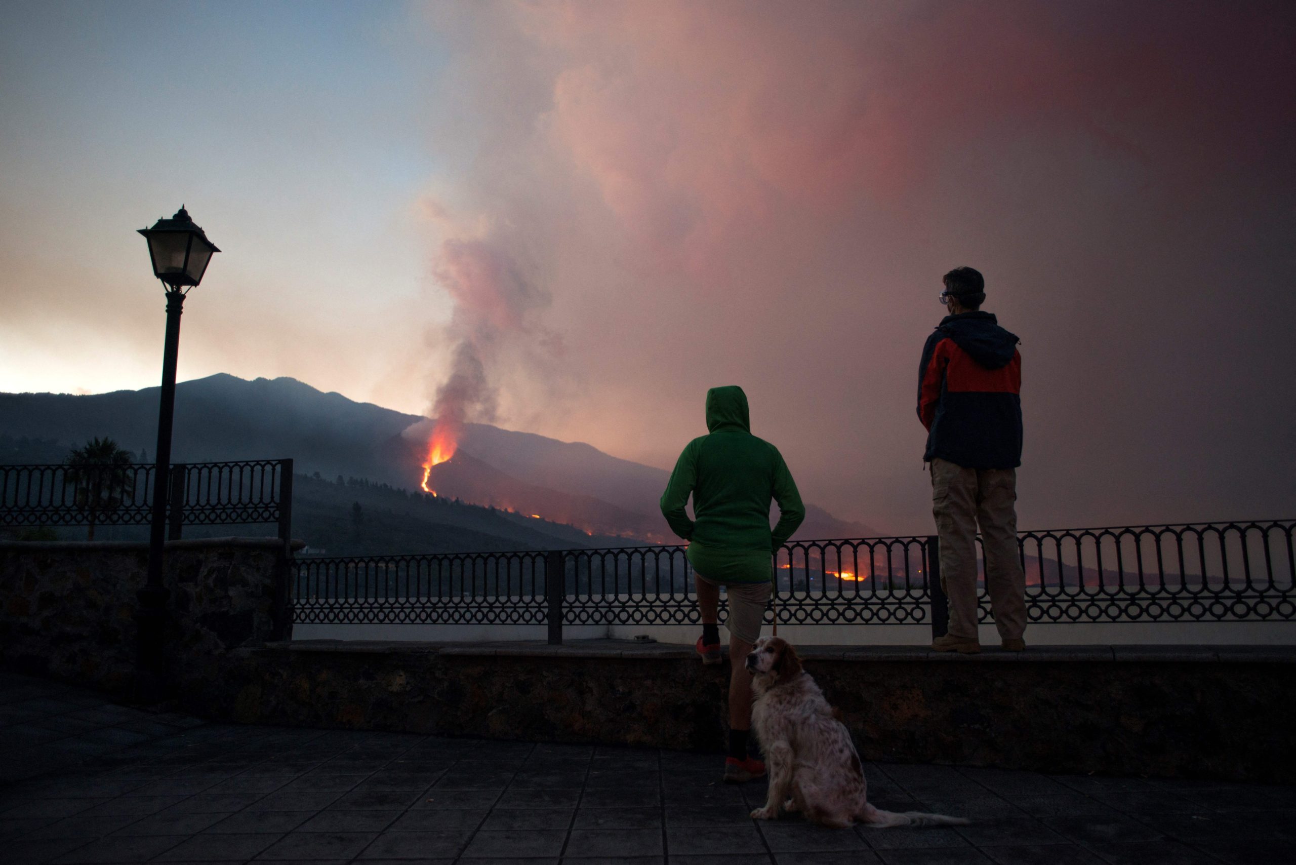 People observe as the Cumbre Vieja volcano spews lava, ash and smoke, in Los Llanos de Aridane, in the Canary Island of La Palma on October 10, 2021. (Photo: Jorge Guerrero/AFP, Getty Images)