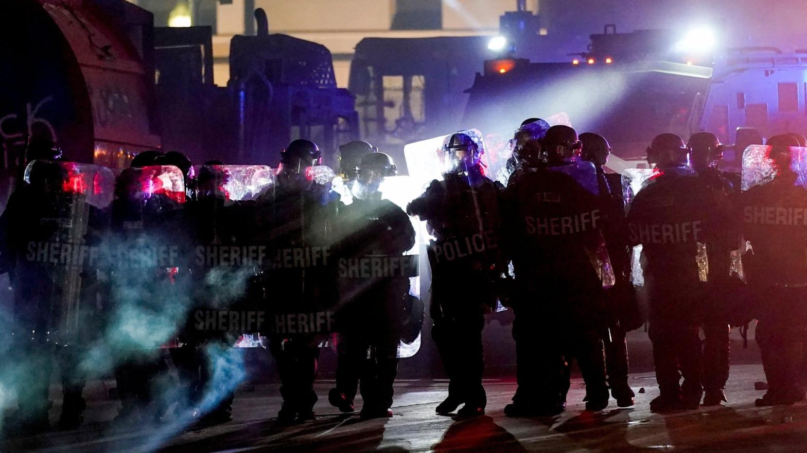Riot police clearing a square in Kenosha, Wisconsin, where an armed group calling itself the Kenosha Guard organised on Facebook to confront Black Lives Matter protesters before a vigilante killed two and wounded another. The Kenosha Guard is now on Facebook's Dangerous Individuals and Organisations list. (Photo: Morry Gash / File, AP)