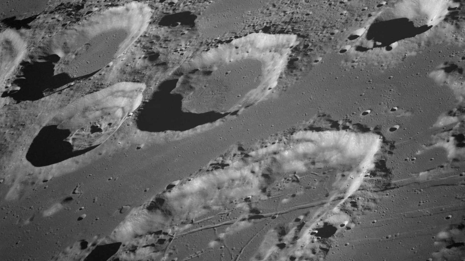 Several craters on the surface of the moon in a black-and-white photo