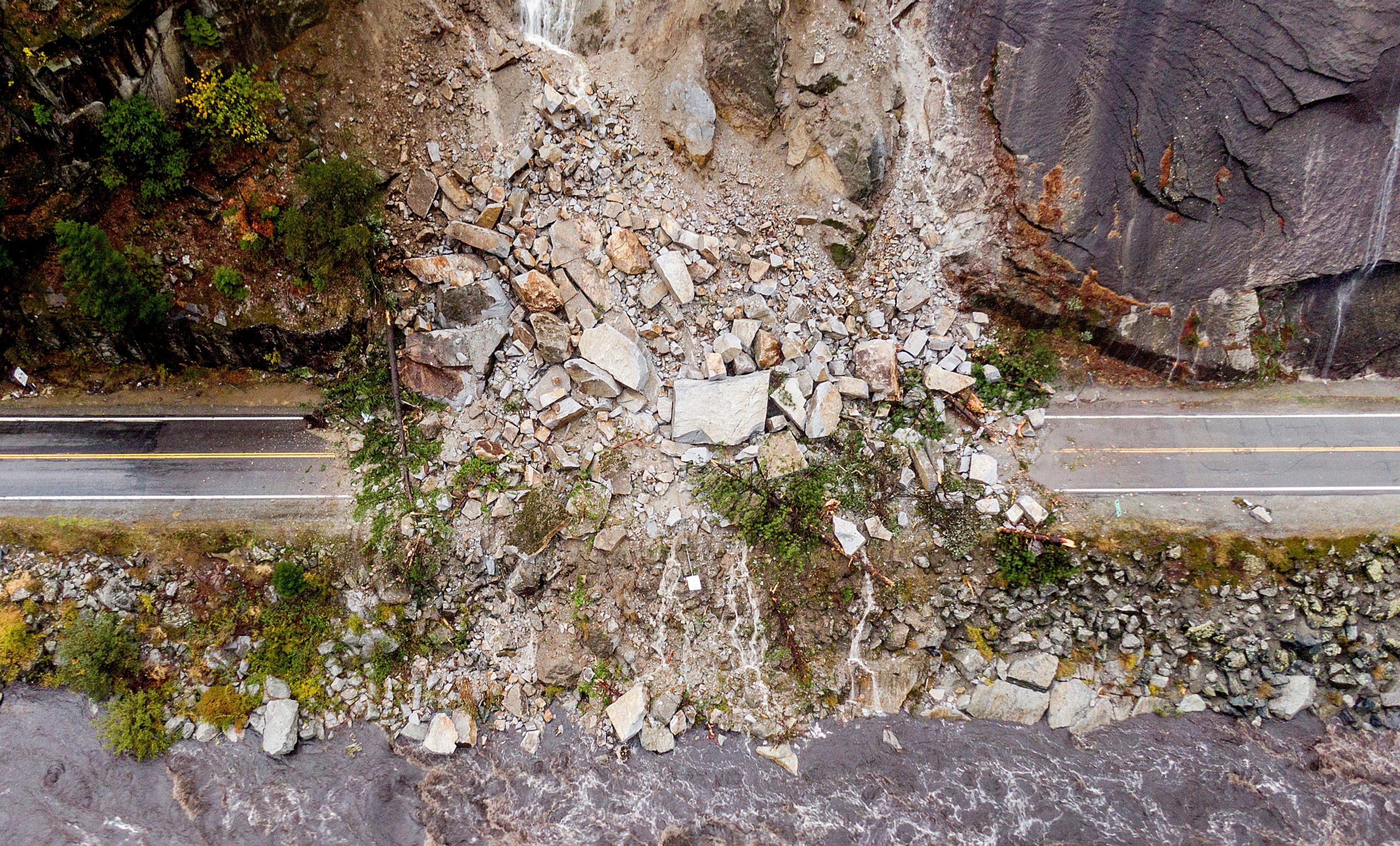An aerial view of rocks and vegetation covering Highway 70 following a landslide in the Dixie Fire zone. (Photo: Noah Berger, AP)