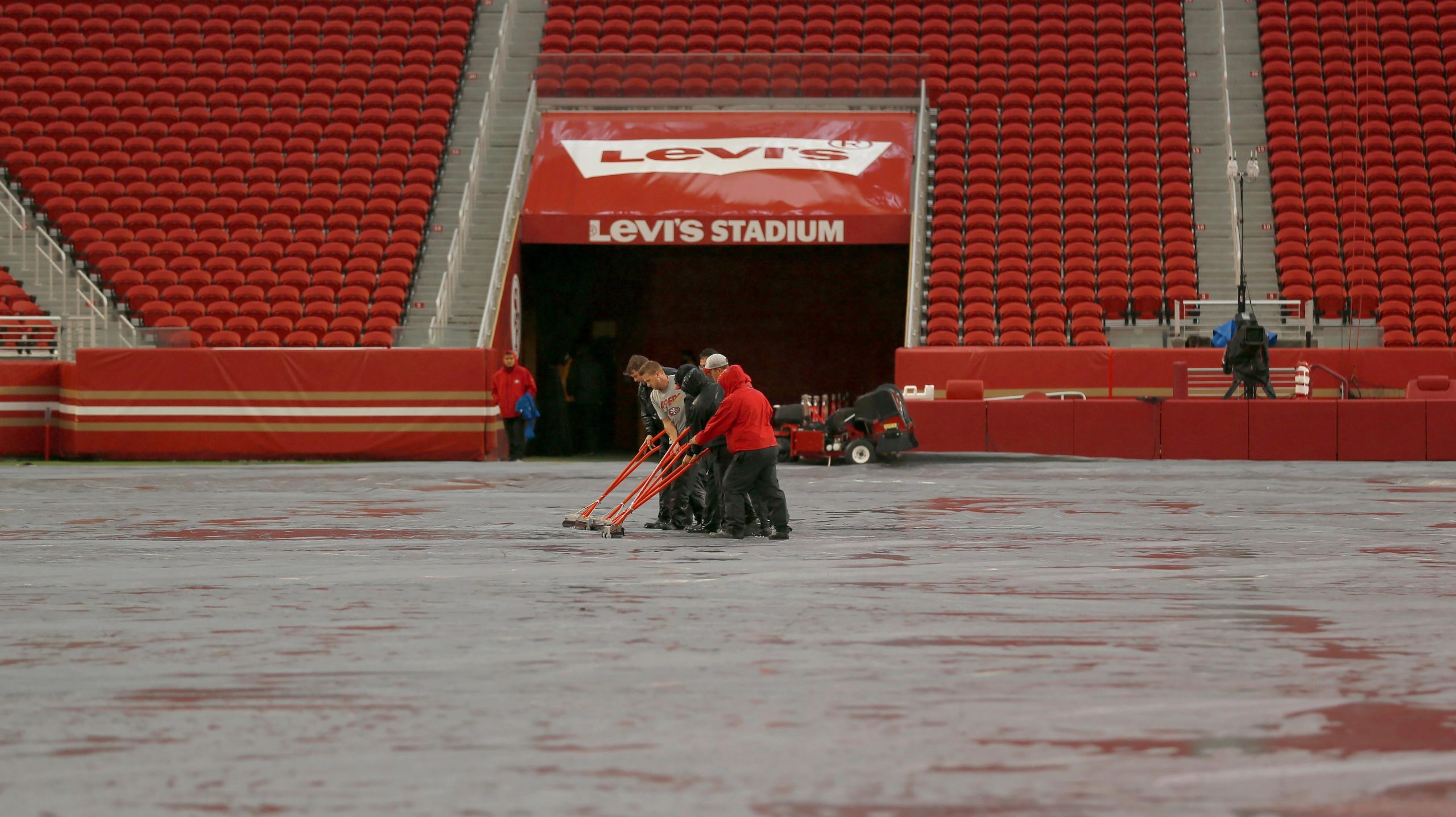 Workers push water off a tarp covering the field from rain at Levi's Stadium before an NFL football game between the San Francisco 49ers and the Indianapolis Colts in Santa Clara, California. (Photo: Jed Jacobsohn, AP)