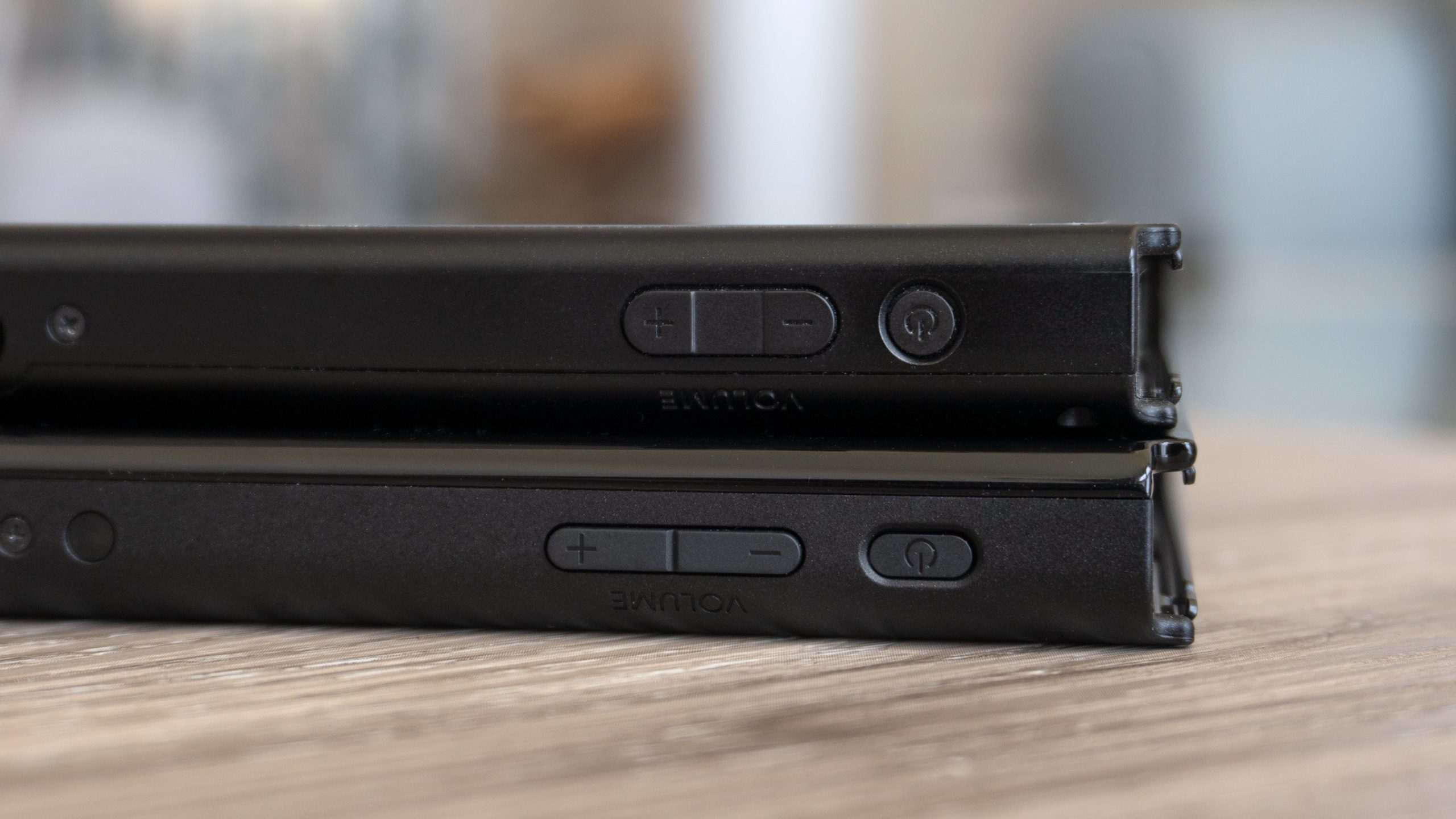 The power and volume buttons on the new Switch OLED (bottom) are slightly longer than those on the original Switch (top). (Photo: Andrew Liszewski - Gizmodo)