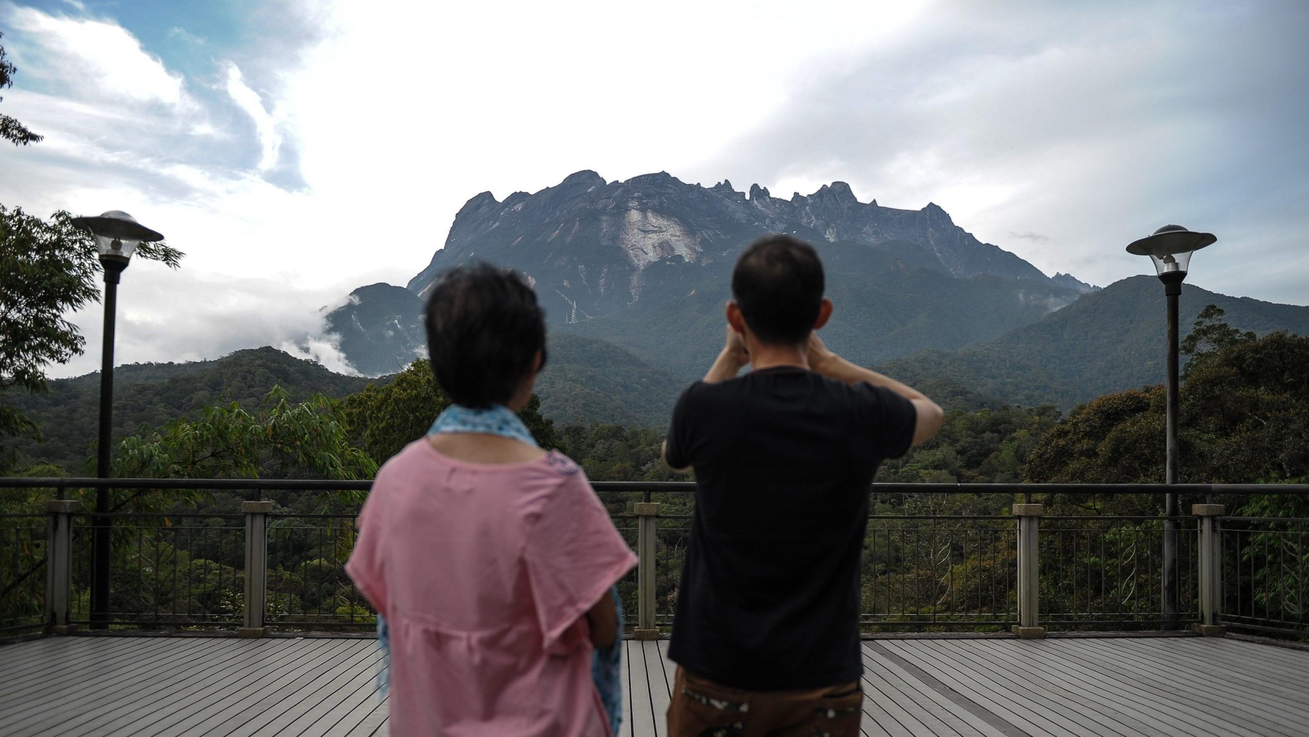  tourist (R) takes pictures of Malaysia's Mount Kinabalu. (Photo: Mohd Rasfan/AFP, Getty Images)