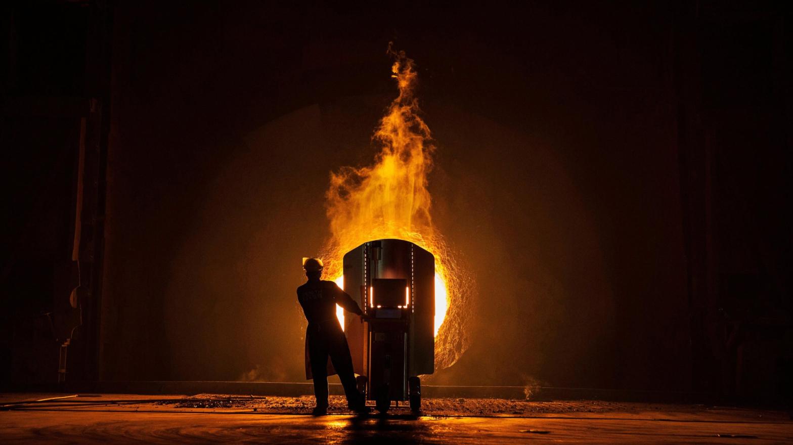 A worker takes samples to measure the quality of molten iron. (Photo: Kevin Frayer, Getty Images)