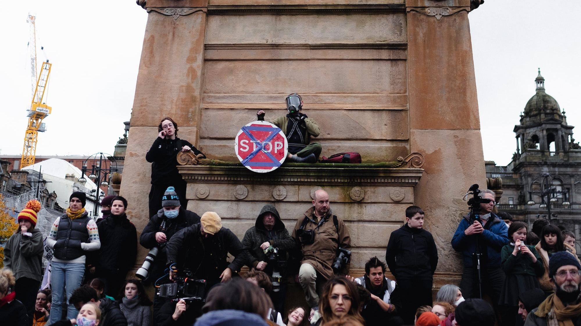 A protester displays the Extinction Rebellion symbol on a stop sign in George Square. (Photo: Brian Kahn)