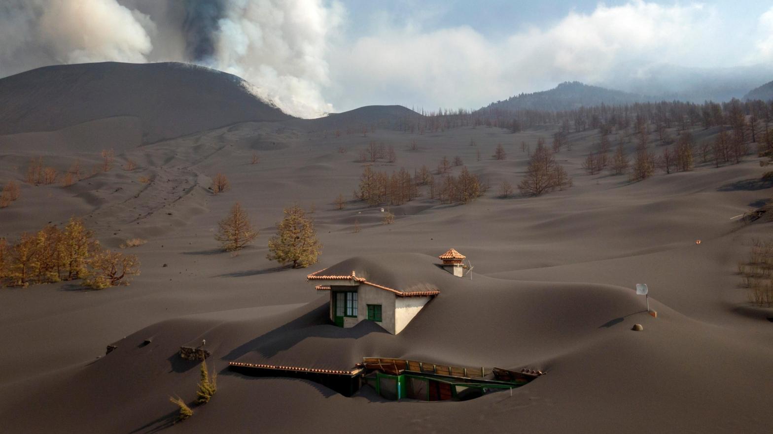 A house is covered by ash from a volcano as it continues to erupt on the Canary island of La Palma, Spain. (Photo: Emilio Morenatti, AP)