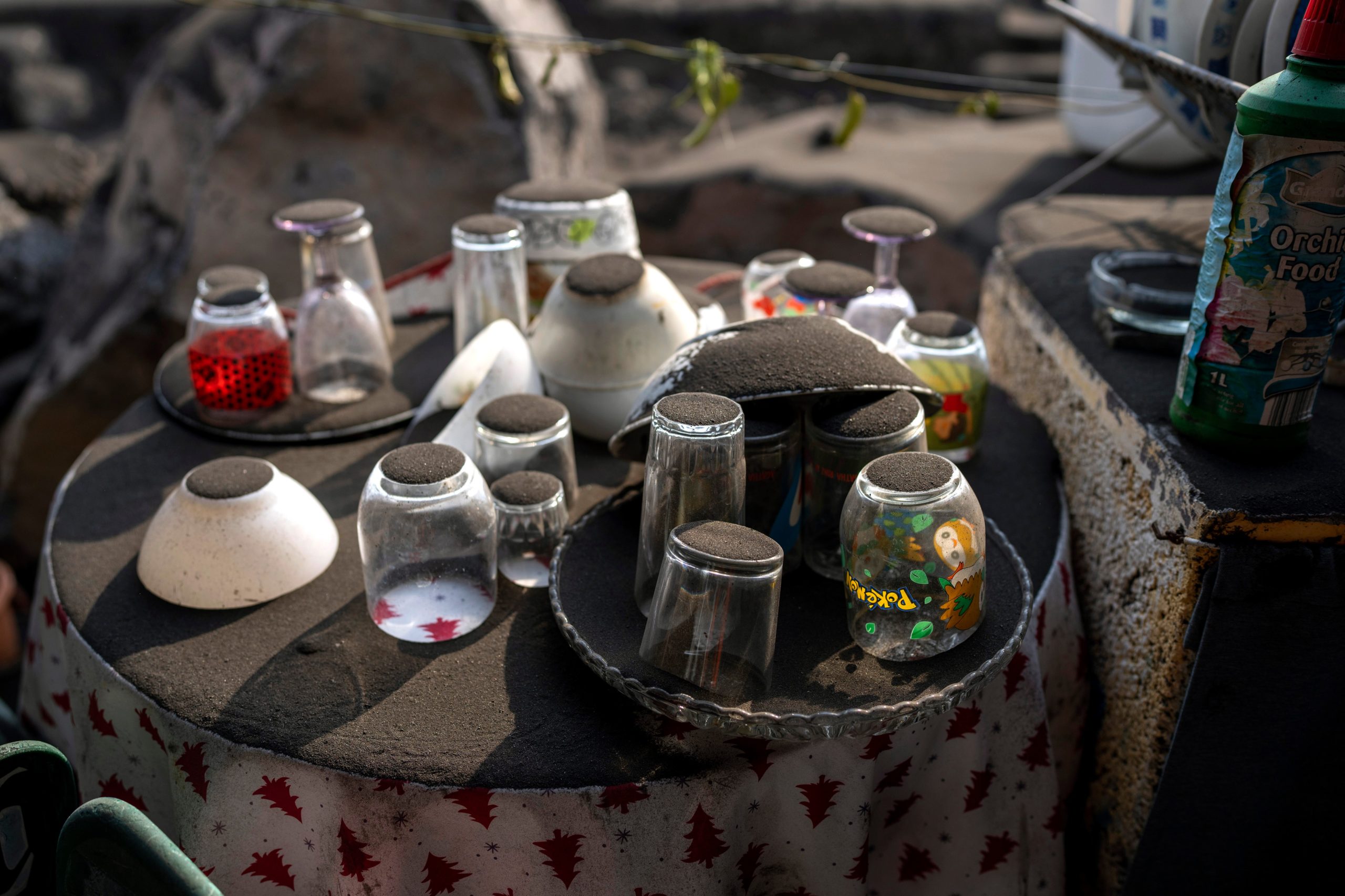 Ash from a volcano covers a crockery set left behind by residents who were evacuated from the village. (Photo: Emilio Morenatti, AP)