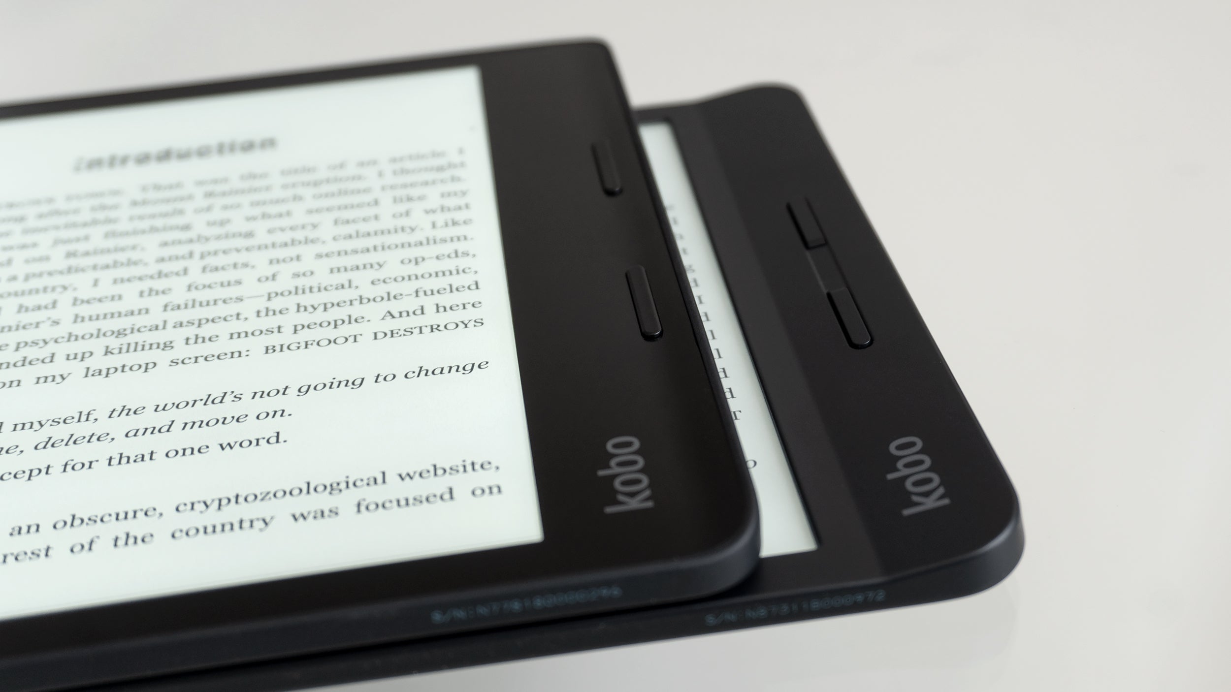 The Kobo Sage (left, top) features the same raised lip on the edge as the Kobo Libra (right, bottom) making it easier to hold and grip single-handed, as well as a pair of page turn navigation buttons. (Photo: Andrew Liszewski - Gizmodo)