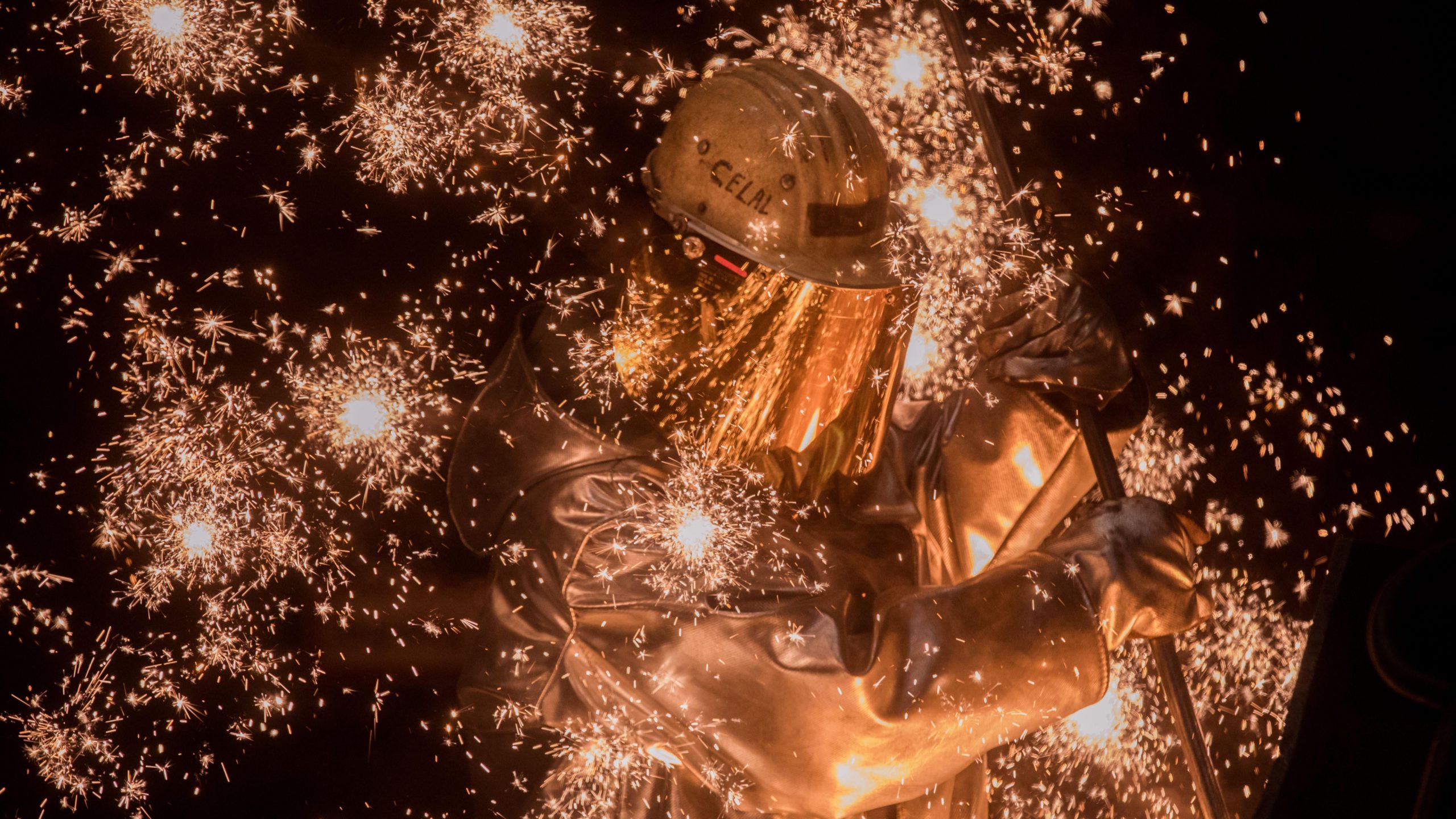 Sparks fly as a worker takes a sample of molten iron flowing from a blast furnace at the Thyssenkrupp Steel Europe steelworks in Germany. (Photo: Sean Gallup, Getty Images)