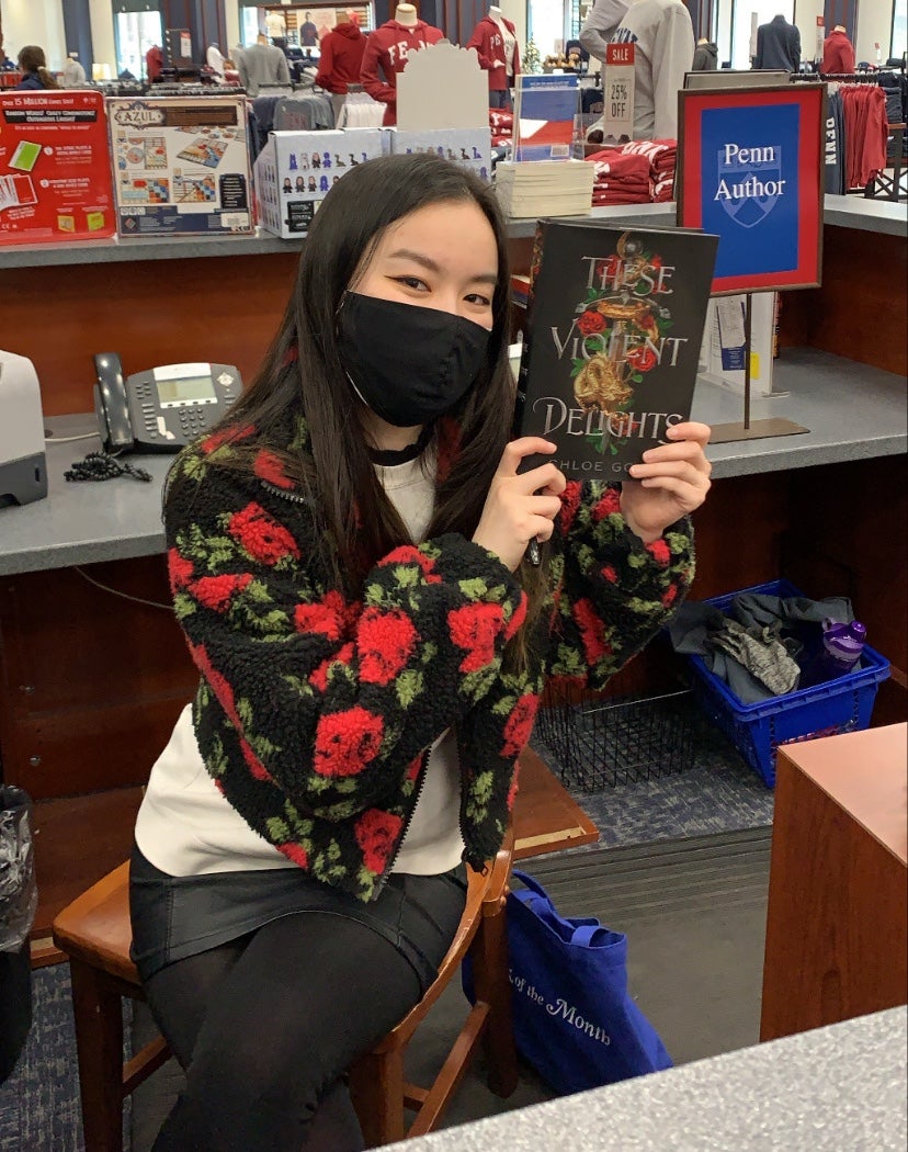 Chloe Gong poses with a copy of her best-selling 2020 debut, These Violent Delights. (Image: Margaret K. McElderry Books)
