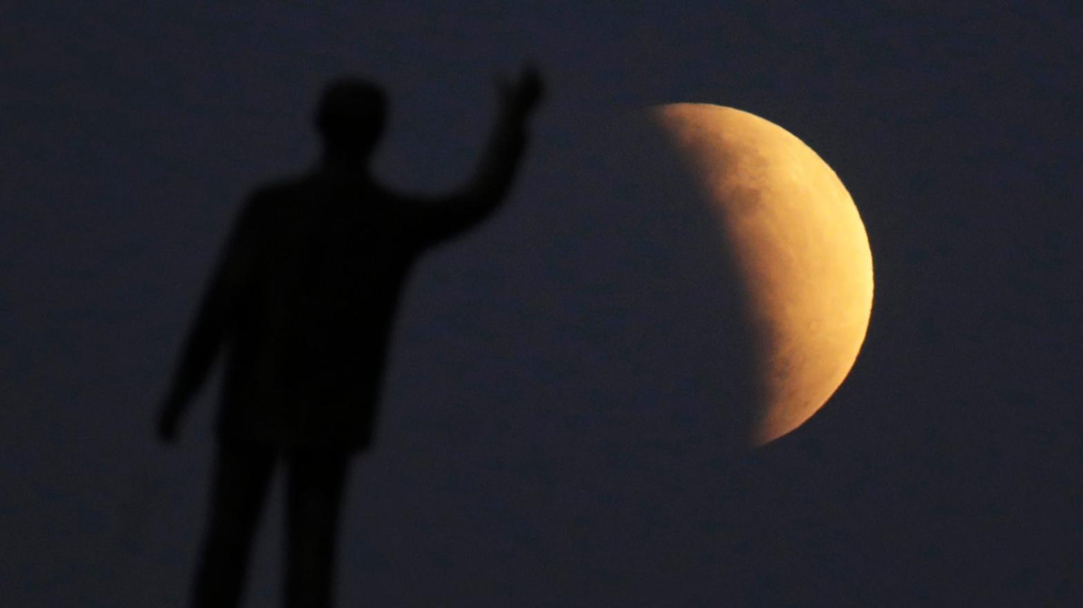 The partial lunar eclipse of July 16, 2019 as seen in Brazil, with a statue in the foreground.  (Photo: Eraldo Peres, AP)