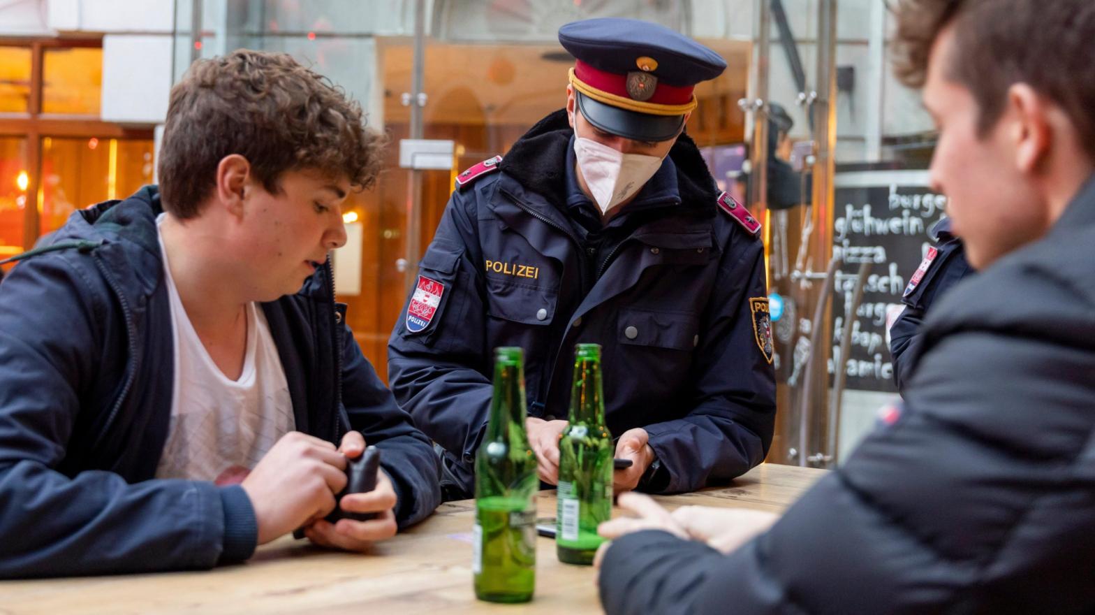 Police officers check the vaccination status of patrons during the first day of a nationwide lockdown for people not yet vaccinated against the covid-19 on November 15, 2021 in Innsbruck, Austria. (Photo: Jan Hetfleisch, Getty Images)
