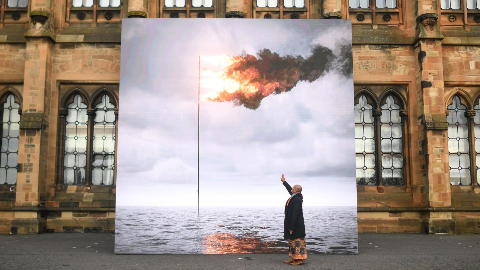 Tongan artist and climate activist, Uili Lousi, is seen with John Gerrards Flare Oceania 2021. (Photo: Peter Summers, Getty Images)