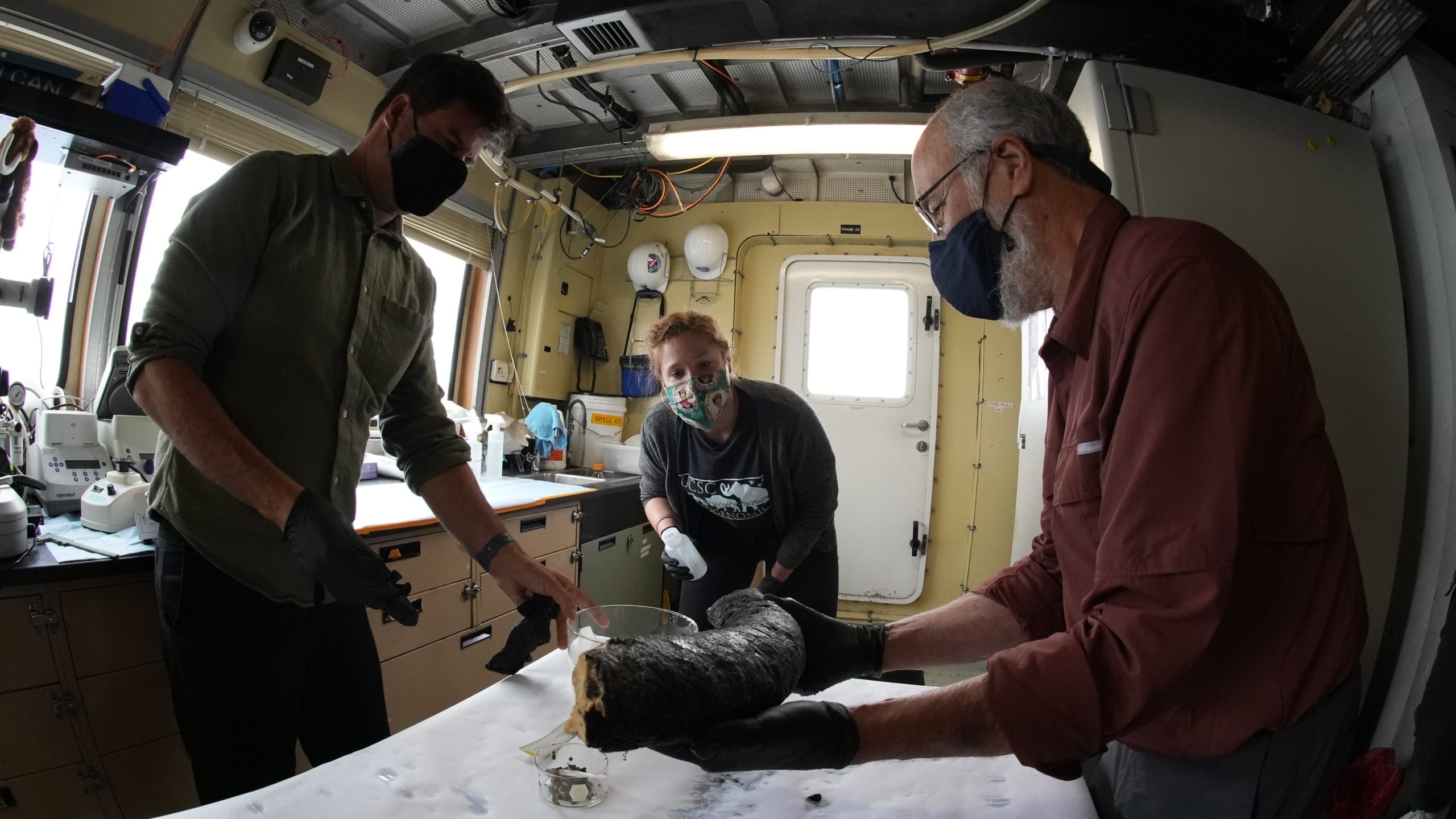 Haddock (left), UC Santa Cruz postdoctoral researcher Katie Moon (centre), and University of Michigan paleontologist Daniel Fisher (right) inspecting the oversized tusk in the ship's lab. (Photo: Darrin Schultz © 2021 MBARI)
