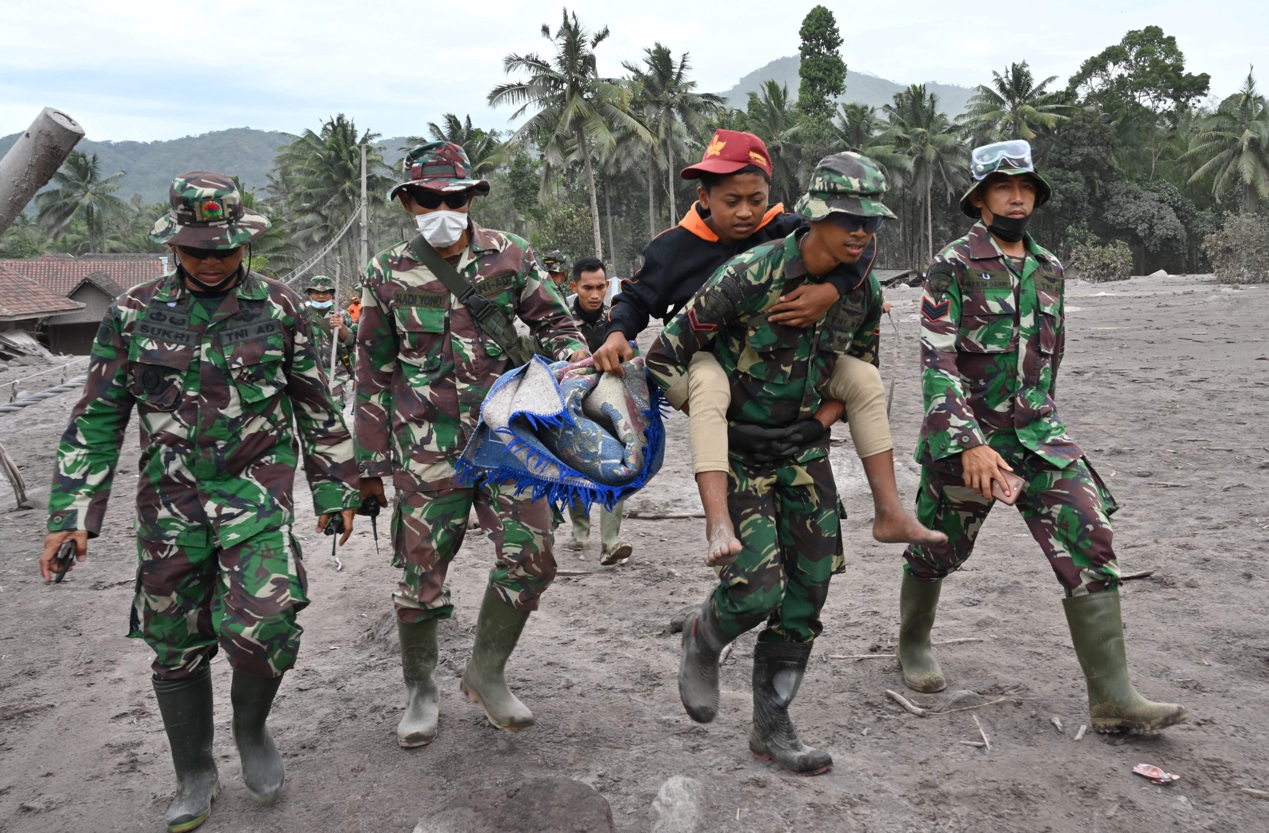 Members of a search and rescue team carry a villager during an operation at the Sumberwuluh village. (Photo: Adek Berry/AFP, Getty Images)