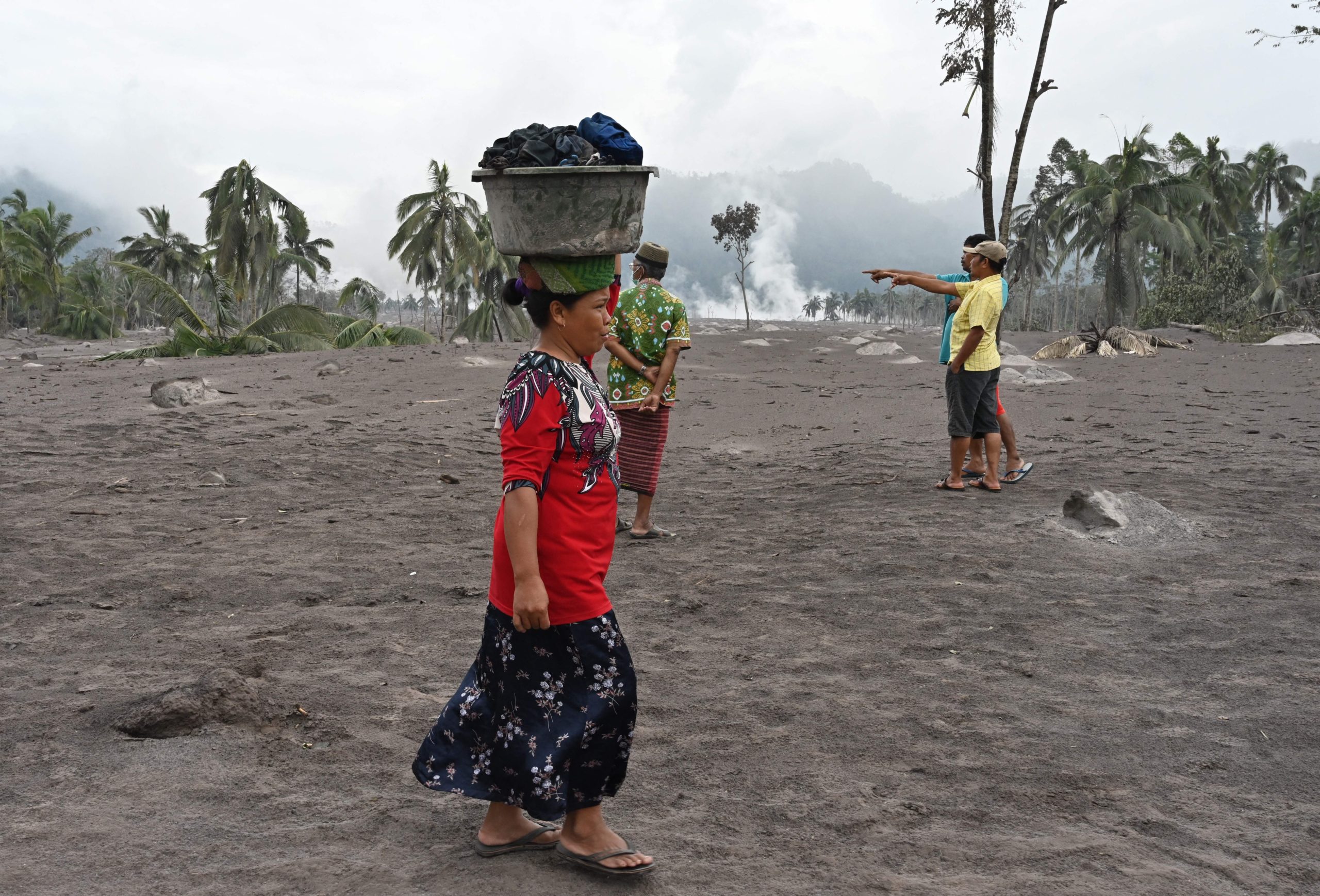A woman salvages her belongings at the Sumberwuluh village. (Photo: Adek Berry/AFP, Getty Images)