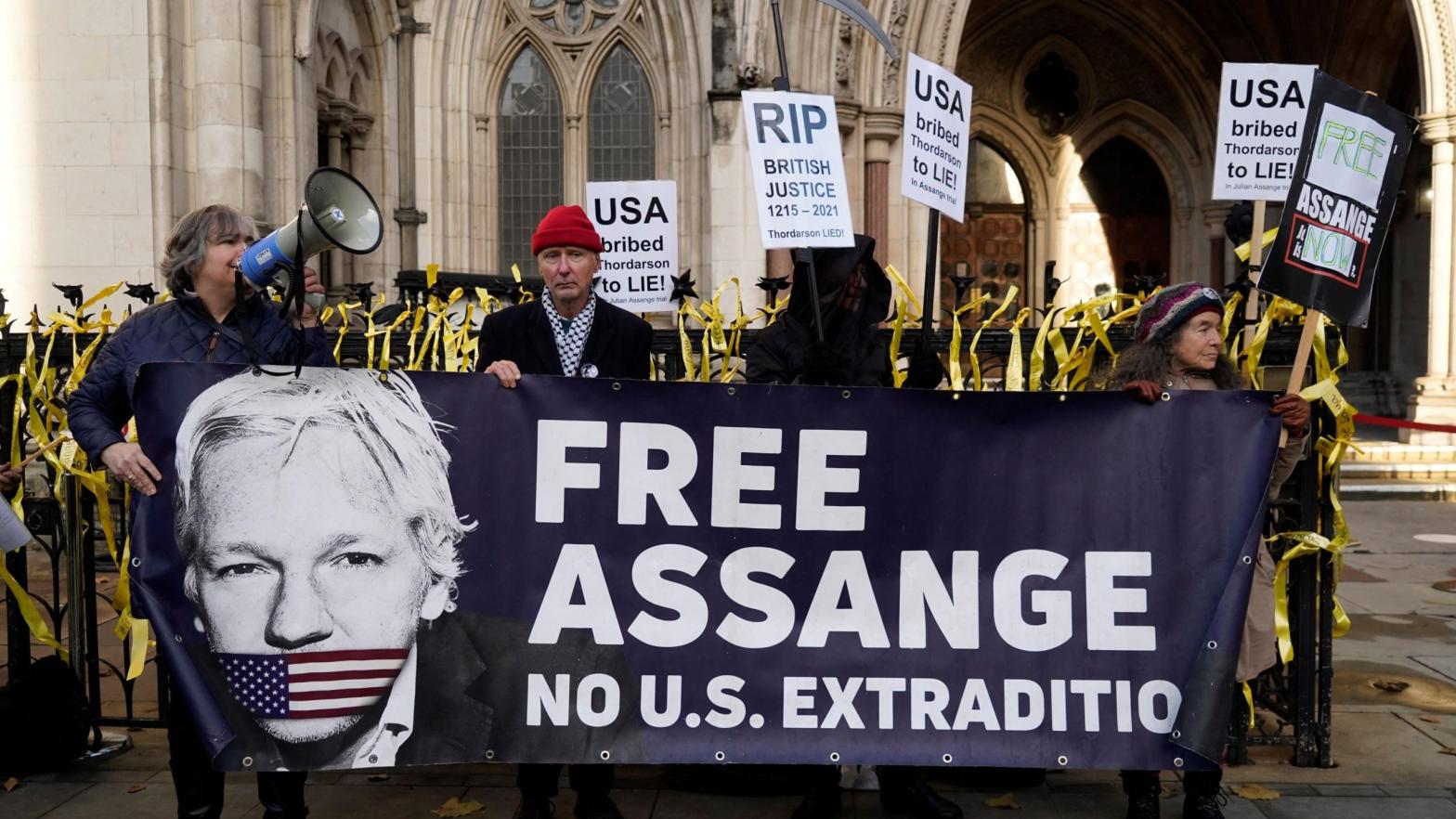 Supporters of WikiLeaks founder Julian Assange, hold placards outside the Royal Courts of Justice in London on December 10, 2021. (Photo: Niklas Halle’n / AFP, Getty Images)