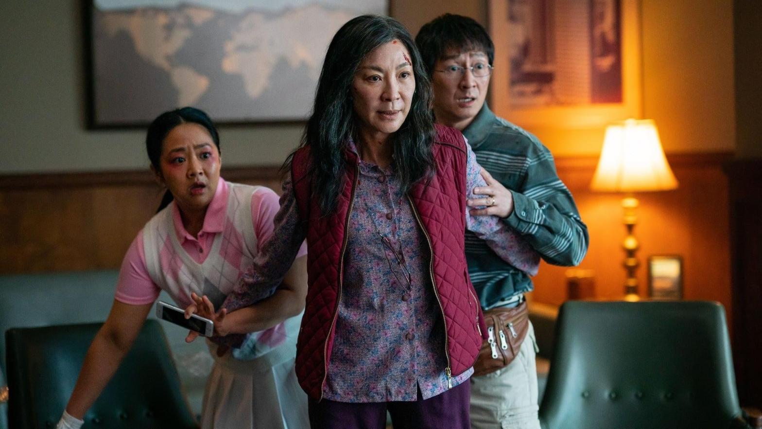 Stephanie Hsu and Ke Huy Quan stand with Michelle Yeoh in Everything Everywhere All at Once. (Image: A24)