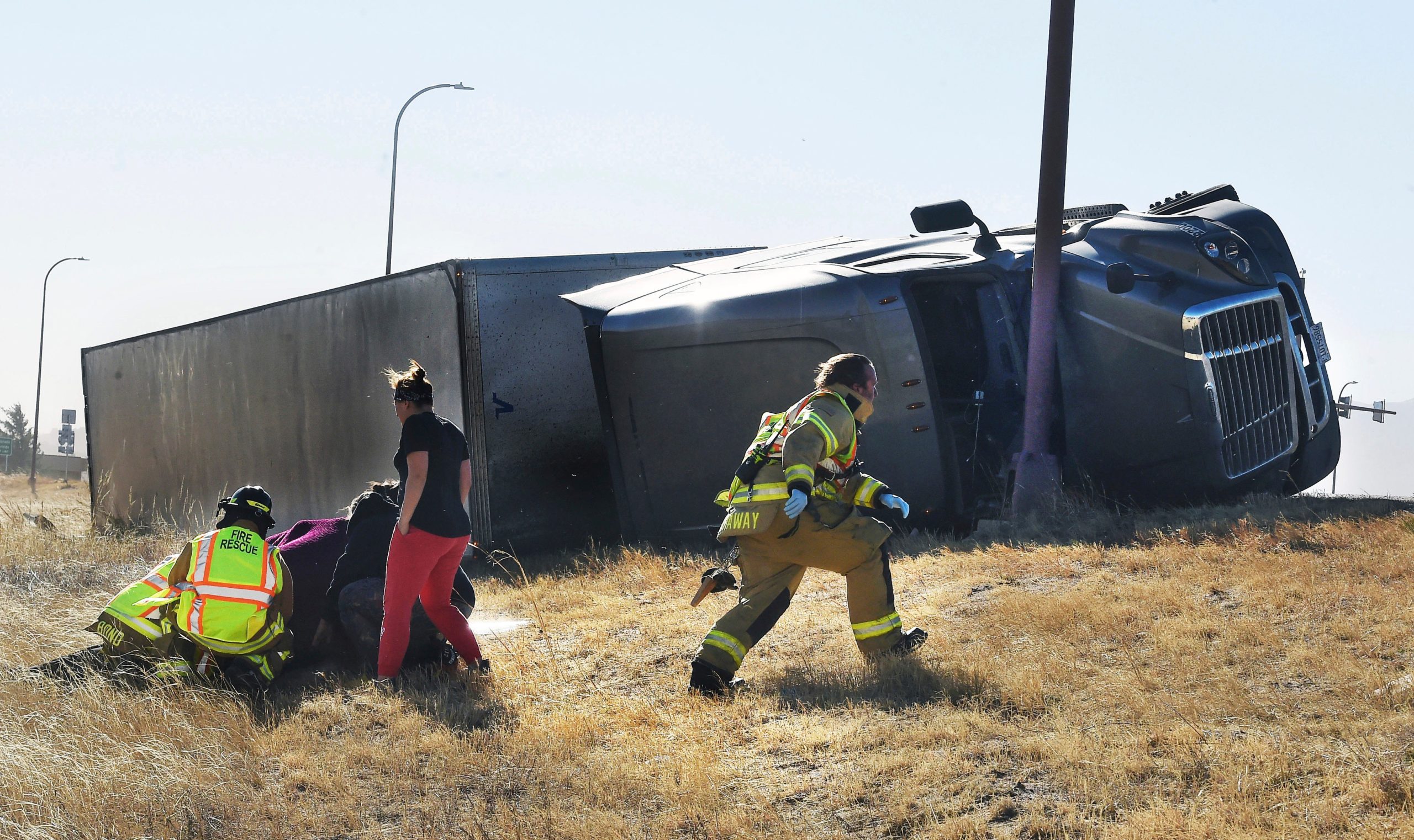 Paramedics tend to an injured person on the onramp of I-25. More than a dozen trucks were blown over by high winds. (Photo: Jerilee Bennett/The Gazette, AP)