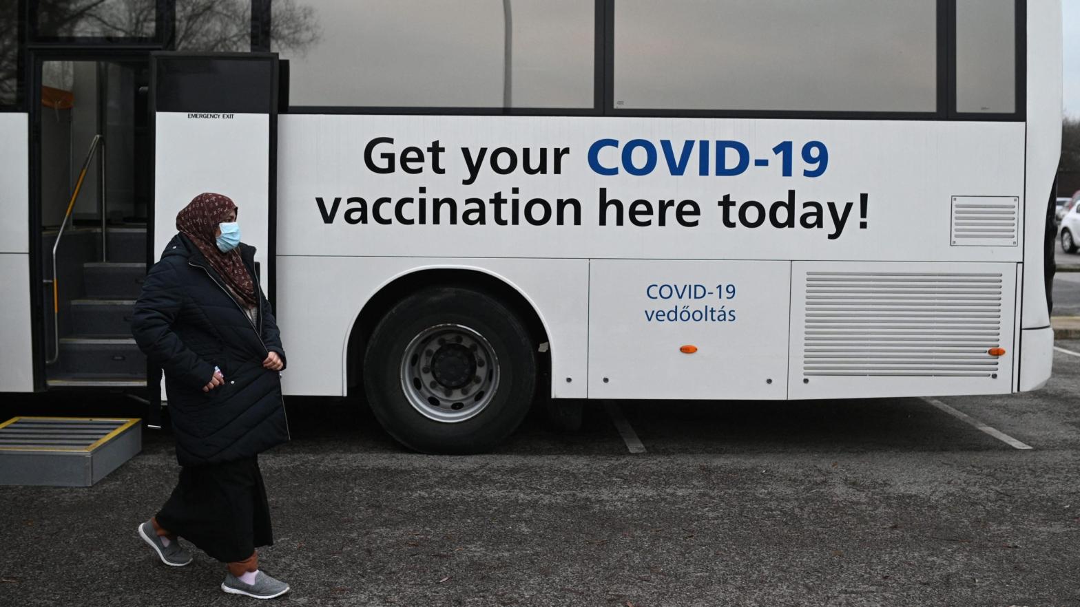 People receiving their covid-19 vaccine or booster at a NHS (National Health Service) bus outside an Asda Supermarket in the town of Farnworth, near Manchester in north-west England on December 20, 2021. (Photo: Oli Scarff/AFP, Getty Images)