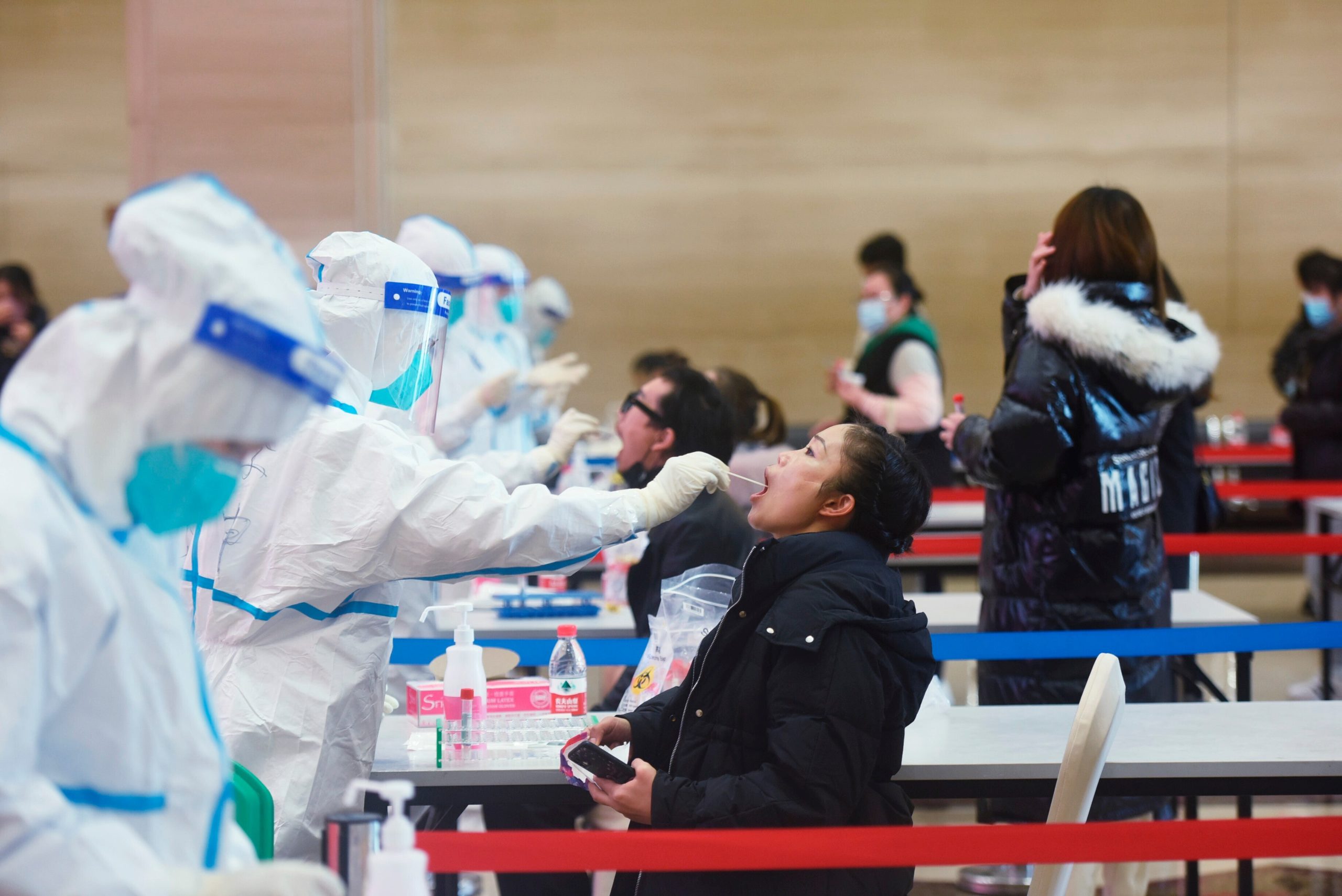 A medical worker takes swab samples during a mandatory covid-19 test on workers of service industries from the Wulin business area in Hangzhou city in east China's Zhejiang province Wednesday, Dec. 15, 2021.  (Photo: FeatureChina, AP)