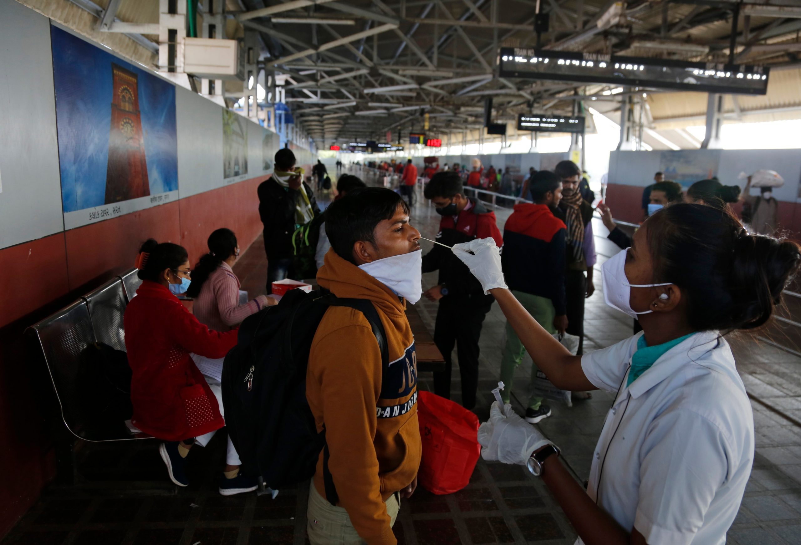 A health worker takes a swab sample of a passenger entering the city to test for COVID-19 at a railway station in Ahmedabad, India, Friday, Dec. 3, 2021. India on Thursday confirmed its first cases of the omicron coronavirus variant in two people and officials said one arrived from South Africa and the other had no travel history. A top medical expert urged people to get vaccinated. (Photo: Ajit Solanki, AP)