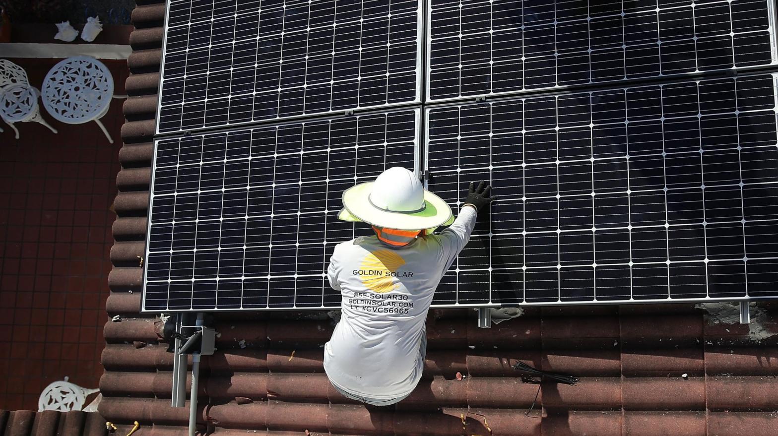 A worker installs a solar panel on a home in Palmetto Bay, Florida. (Photo: Joe Raedle, Getty Images)