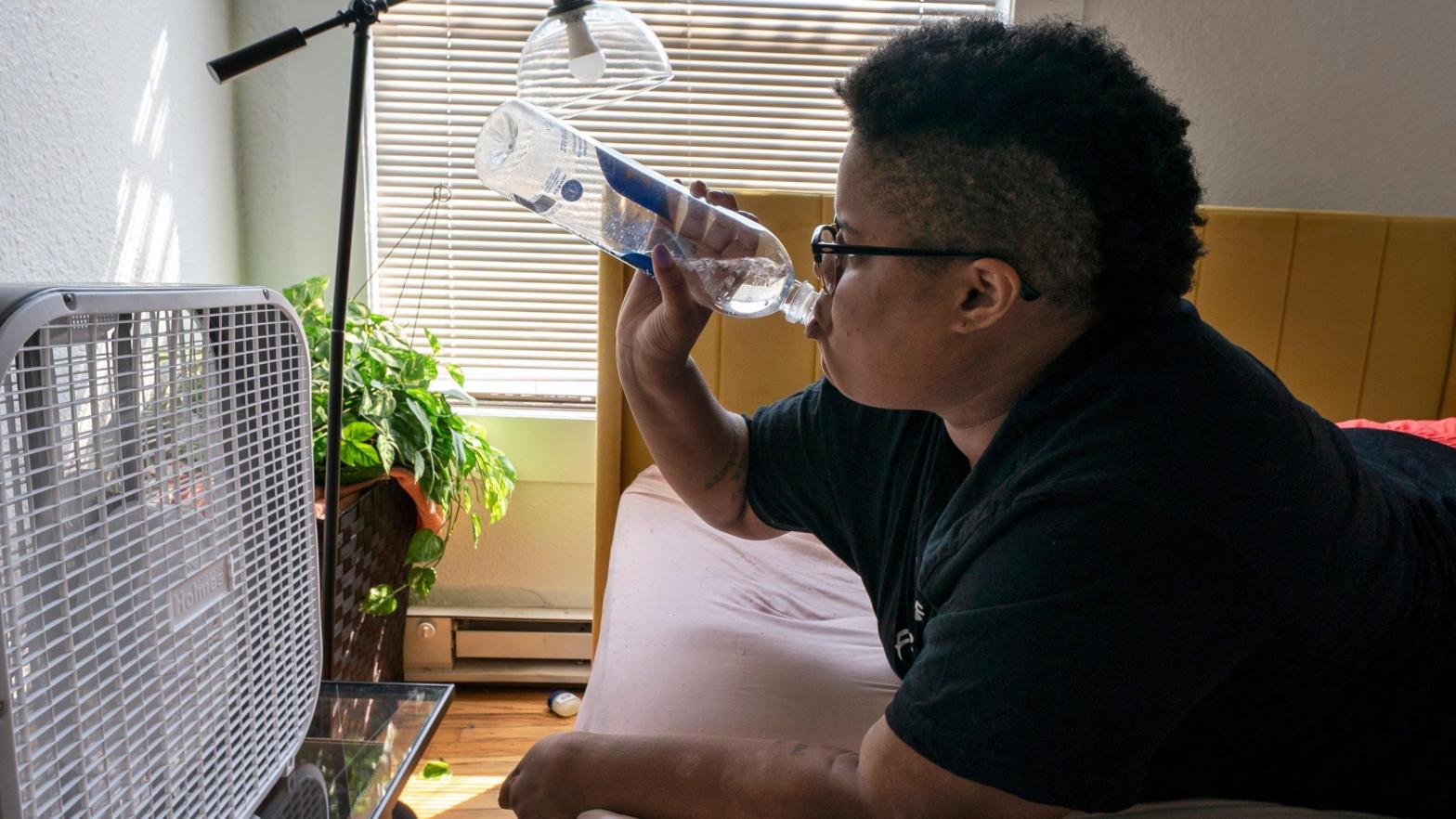 Katherine Morgan drinks water in front of a box fan while trying to stay cool in her downtown apartment without air conditioning on Thursday, Aug. 12, 2021, in Portland, Oregon. (Photo: Nathan Howard, AP)