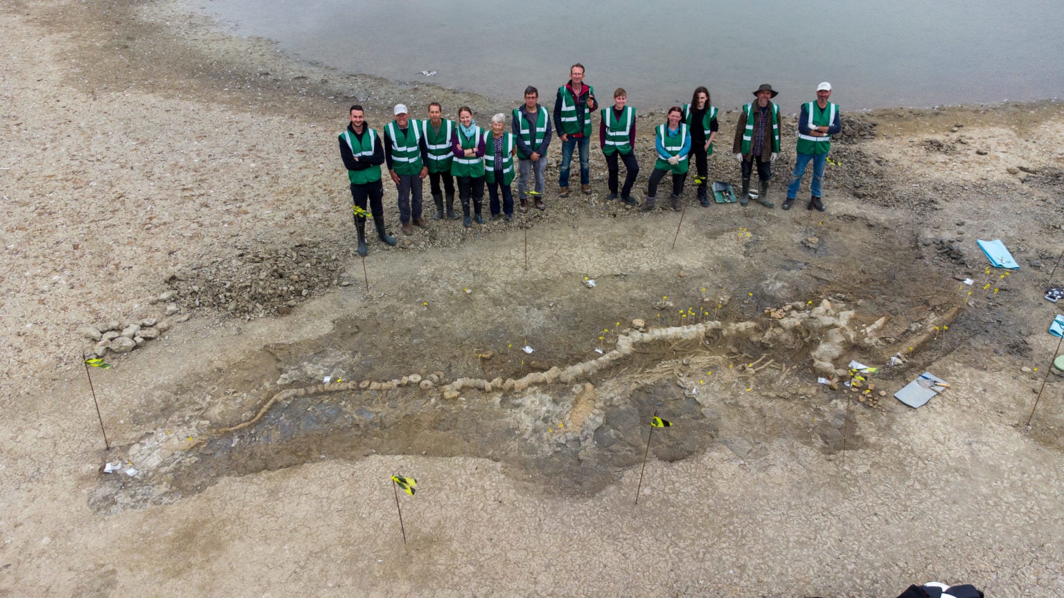 Paleontologists standing next to the ichthyosaur fossil.  (Photo: Anglian Water)