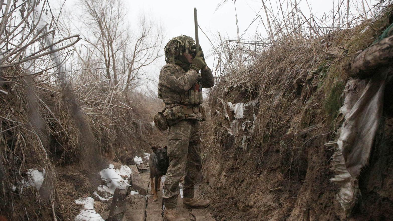 Ukrainian Military Forces serviceman watches through spyglass in a trench on the frontline with Russia-backed separatists near Avdiivka, southeastern Ukraine, on January 9, 2022. (Photo: Anatolii Stepanova / AFP, Getty Images)