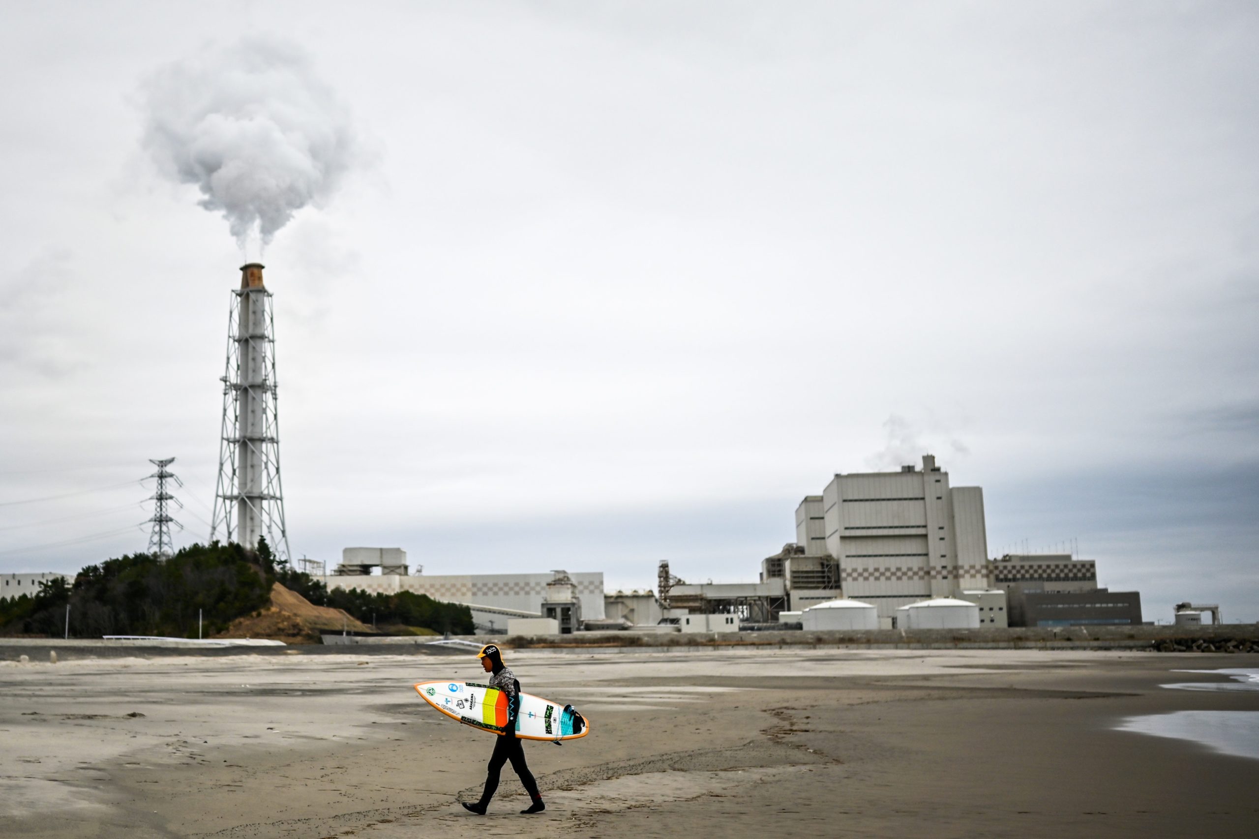 Koji Suzuki, a surfer and a surf shop owner, walking on the beach in front of a thermal power station after a surfing session in Minamisoma, Fukushima prefecture. (Photo: Charly Triballeau/AFP, Getty Images)