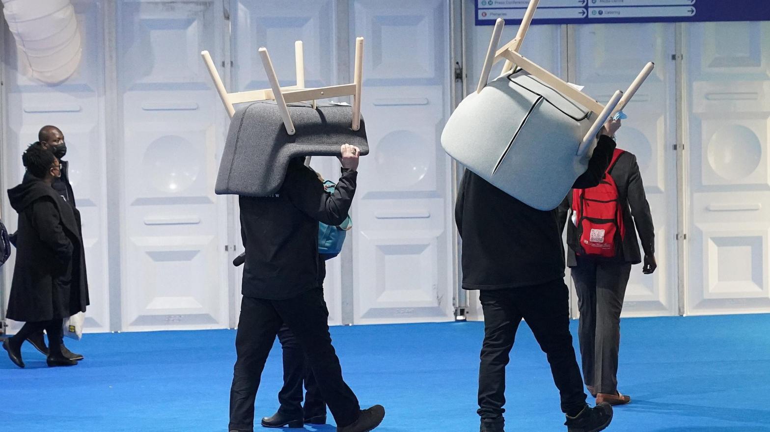Workers carry chairs supplied by Swedish furniture maker IKEA. IKEA provided seating and tables for delegates at COP26 in 2021 in Glasgow, Scotland. (Photo: Christopher Furlong, Getty Images)