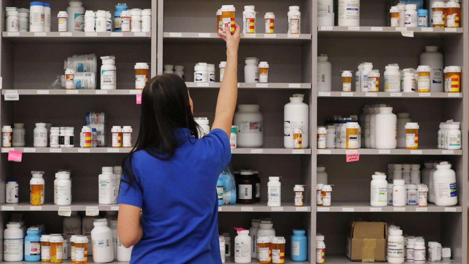 A pharmacy technician grabs a bottle of drugs off a shelve at a pharmacy.  (Photo: George Frey, Getty Images)