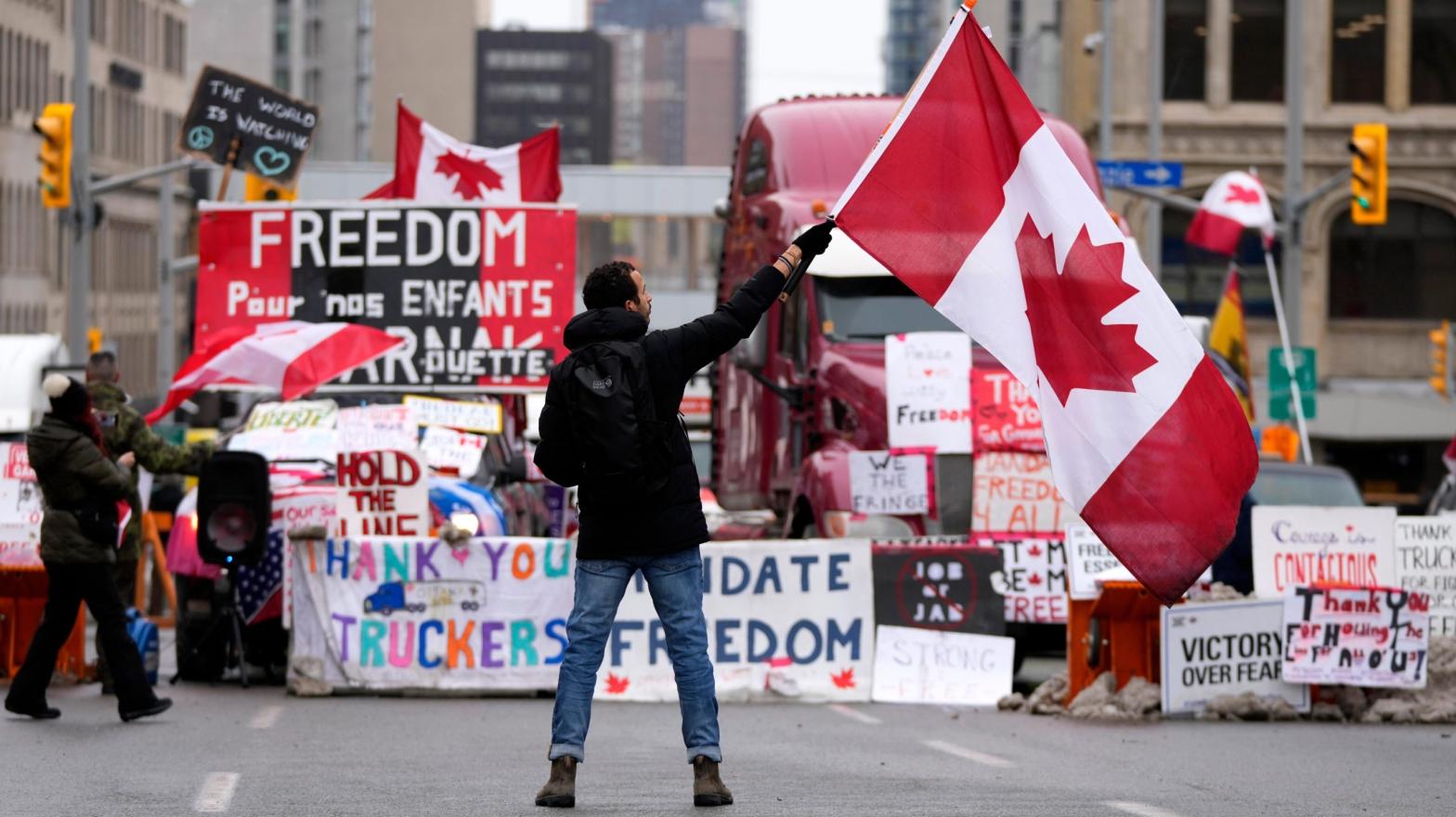 A protester waves a Canadian flag in front of parked vehicles on Rideau Street at a protest against COVID-19 measures that has grown into a broader anti-government protest, in Ottawa, Ontario, Friday, Feb. 11, 2022.  (Photo: Justin Tang/The Canadian Press via AP, AP)