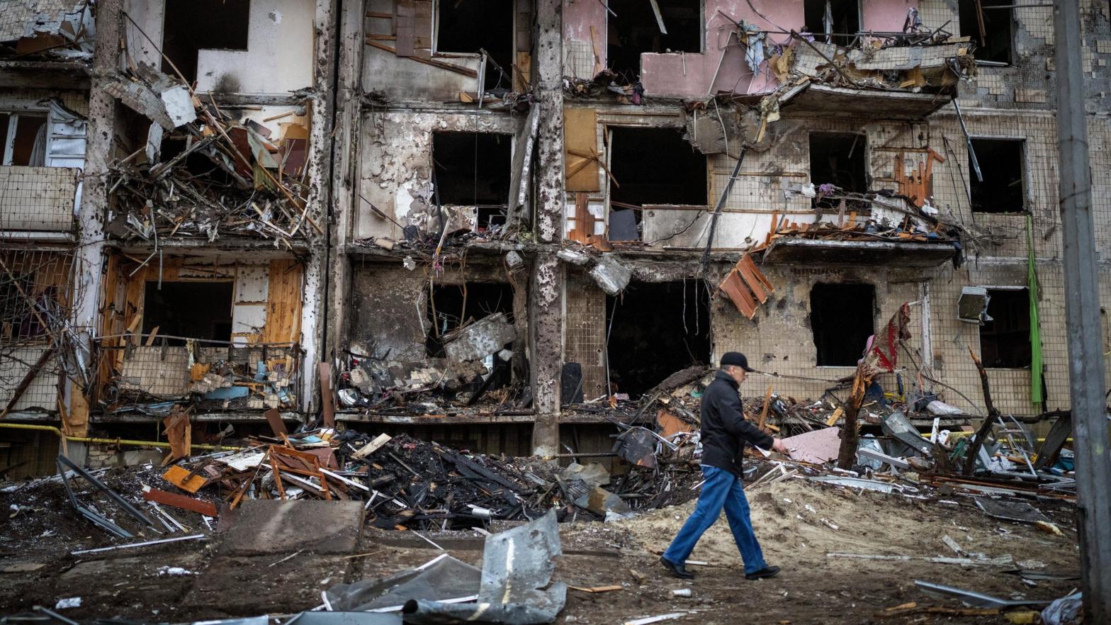 A man walks past a building damaged following a Russian rocket attack in the city of Kyiv, Ukraine on Feb. 25, 2022. (Photo: Emilio Morenatti, AP)