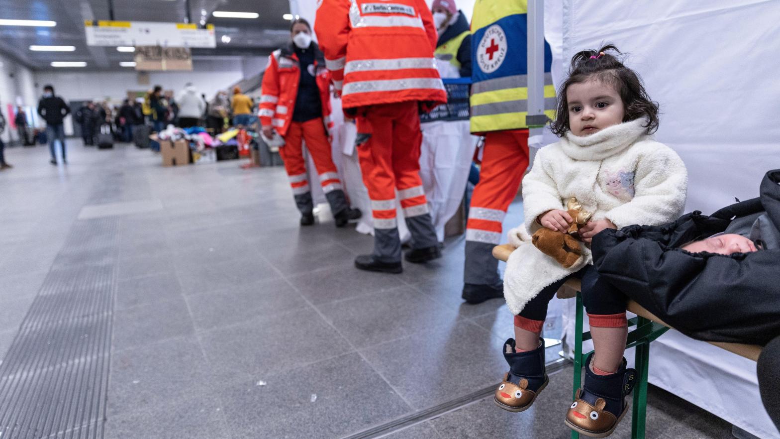 A little girl and a baby wait next to the Red Cross station as people fleeing Ukraine arrive on a train from Poland at Hauptbahnhof railway station on March 4, 2022 in Berlin, Germany.  (Photo: Maja Hitij, Getty Images)