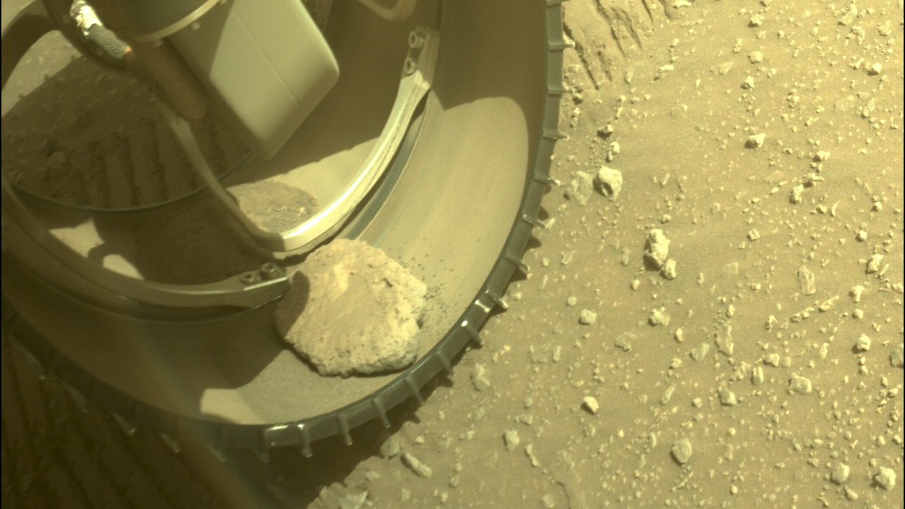The stone sitting inside the interior of one of Percy's six aluminium wheels, in an image captured on February 25, 2022.  (Image: NASA/JPL-Caltech)