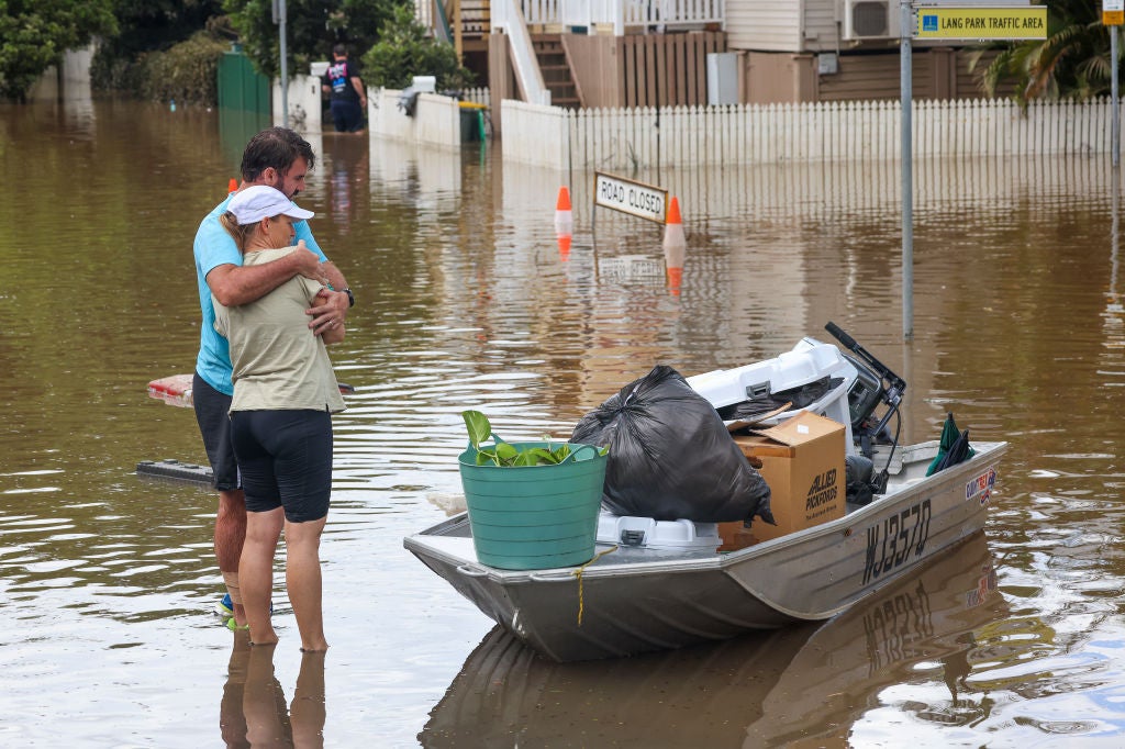 People hug after moving their belongings to a boat from a flooded home at Torwood Street, Auchenflower in Brisbane, Australia. March 3, 2022 (Photo: Peter Wallis, Getty Images)