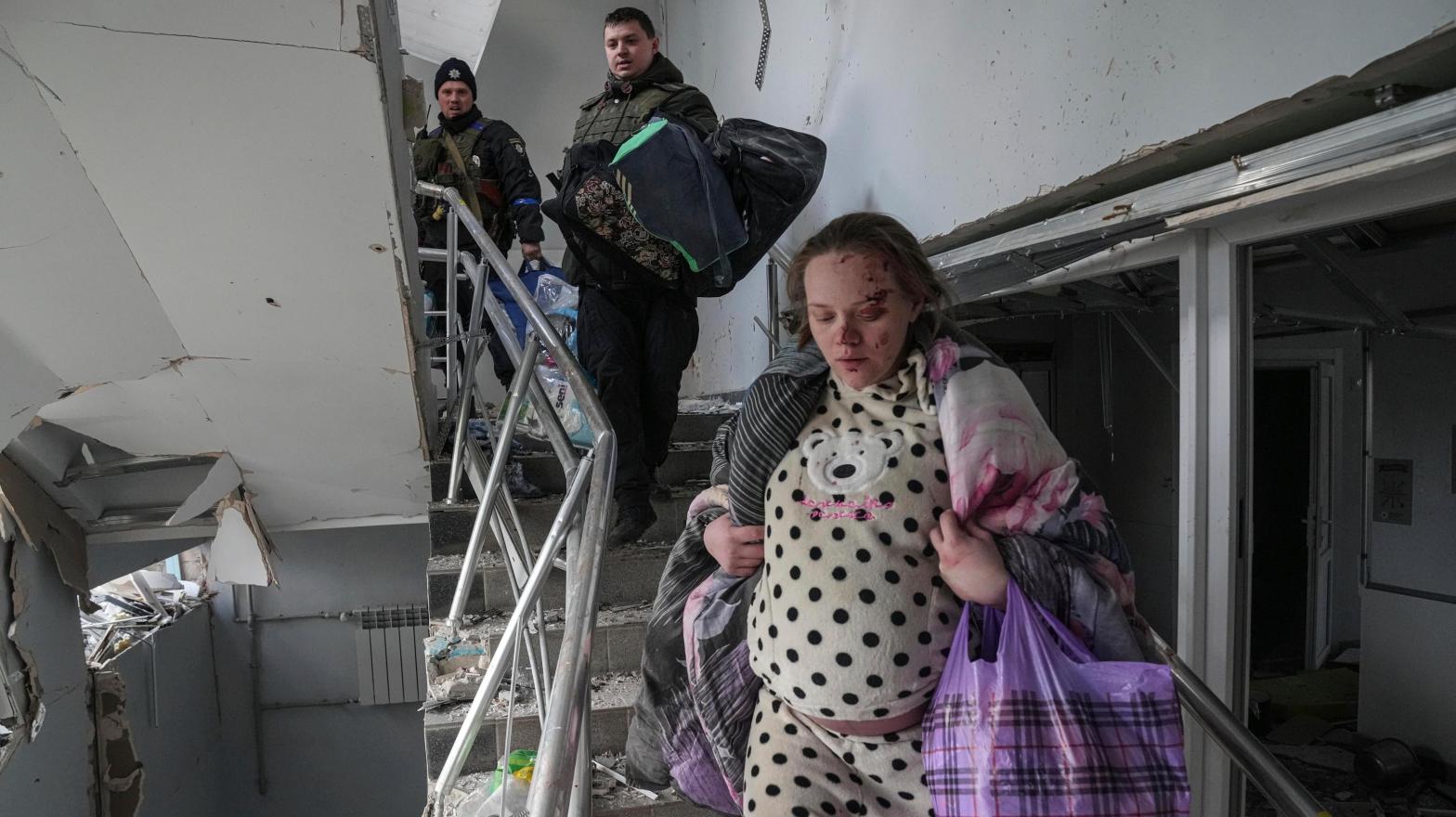 An injured pregnant woman walks downstairs in a maternity hospital  damaged by shelling in Mariupol, Ukraine, on March 9, 2022. (Photo: Evgeniy Maloletka, AP)
