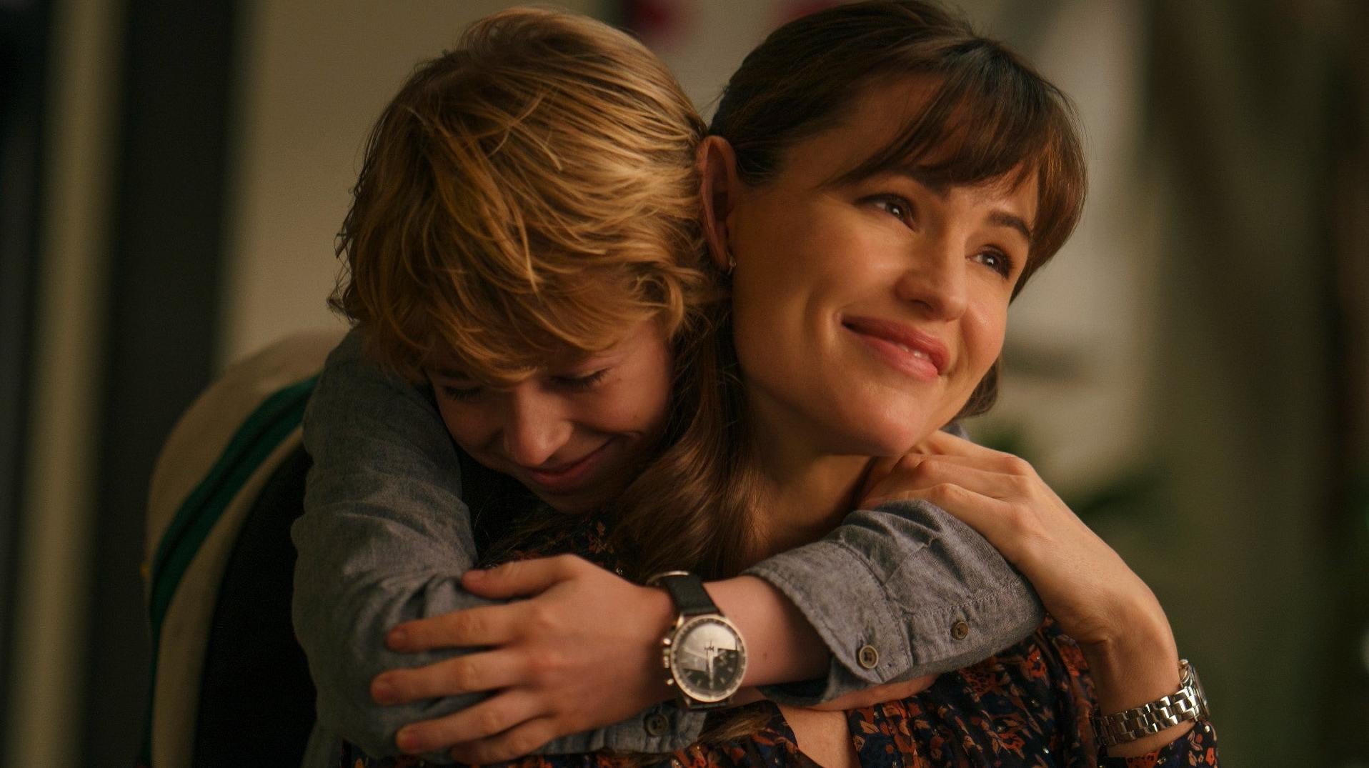 Young Adam (Walker Scobell) hugs his mum, played by Jennifer Garner. (Image: Netflix)