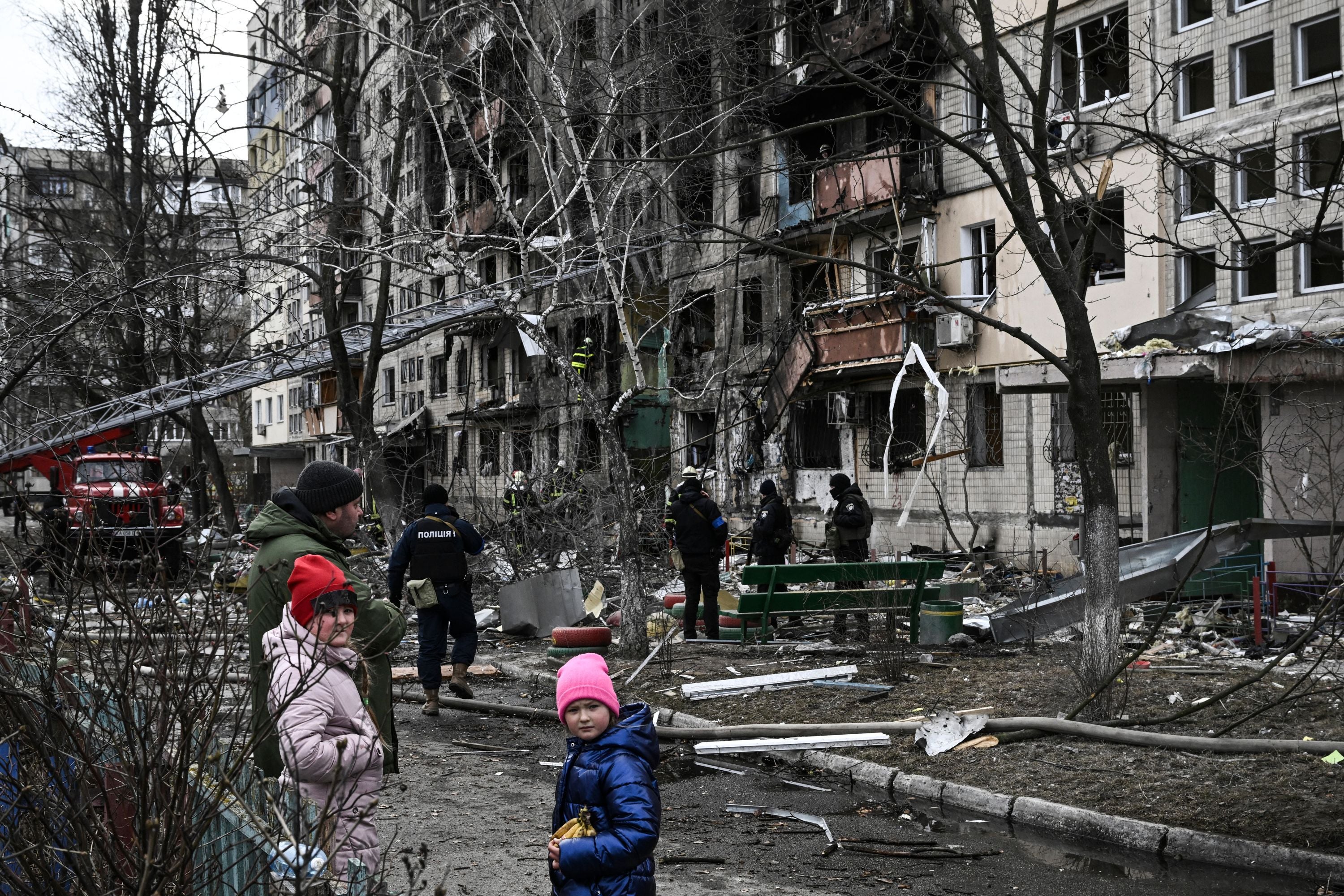Children stand in front of a destroyed apartment building  following Russian shelling in the northwestern Obolon district of Kyiv, Ukraine on March  14, 2022. (Photo: Aris Messinis / AFP, Getty Images)