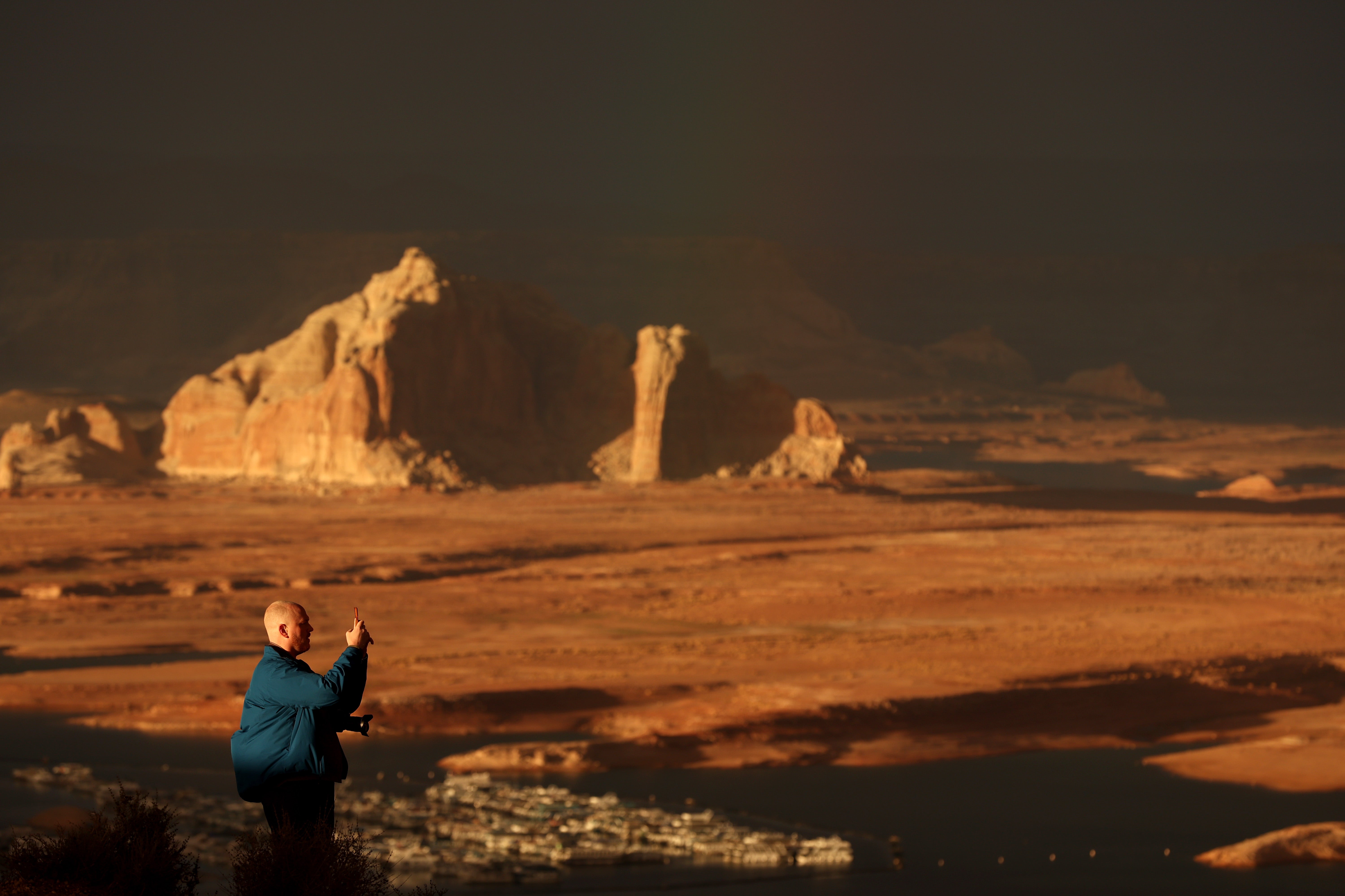 A park visitor takes a picture of Lake Powell at sunset. (Photo: Justin Sullivan, Getty Images)