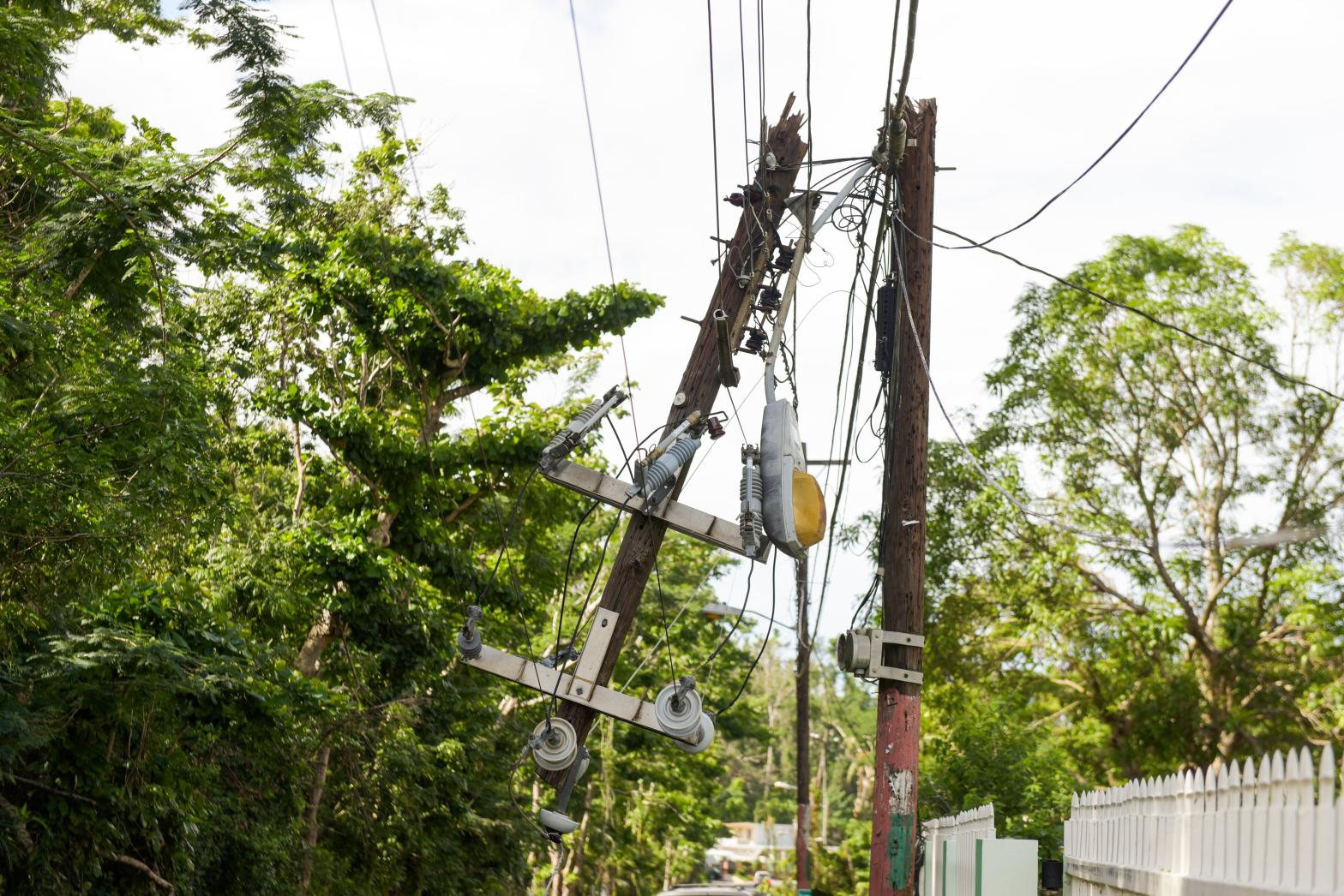 Hurricane Maria aftermath in Puerto Rico. Dangerous power lines and power pole dangle over street traffic in Vega Alta, Puerto Rico (Photo: alejandrophotography, Getty Images)