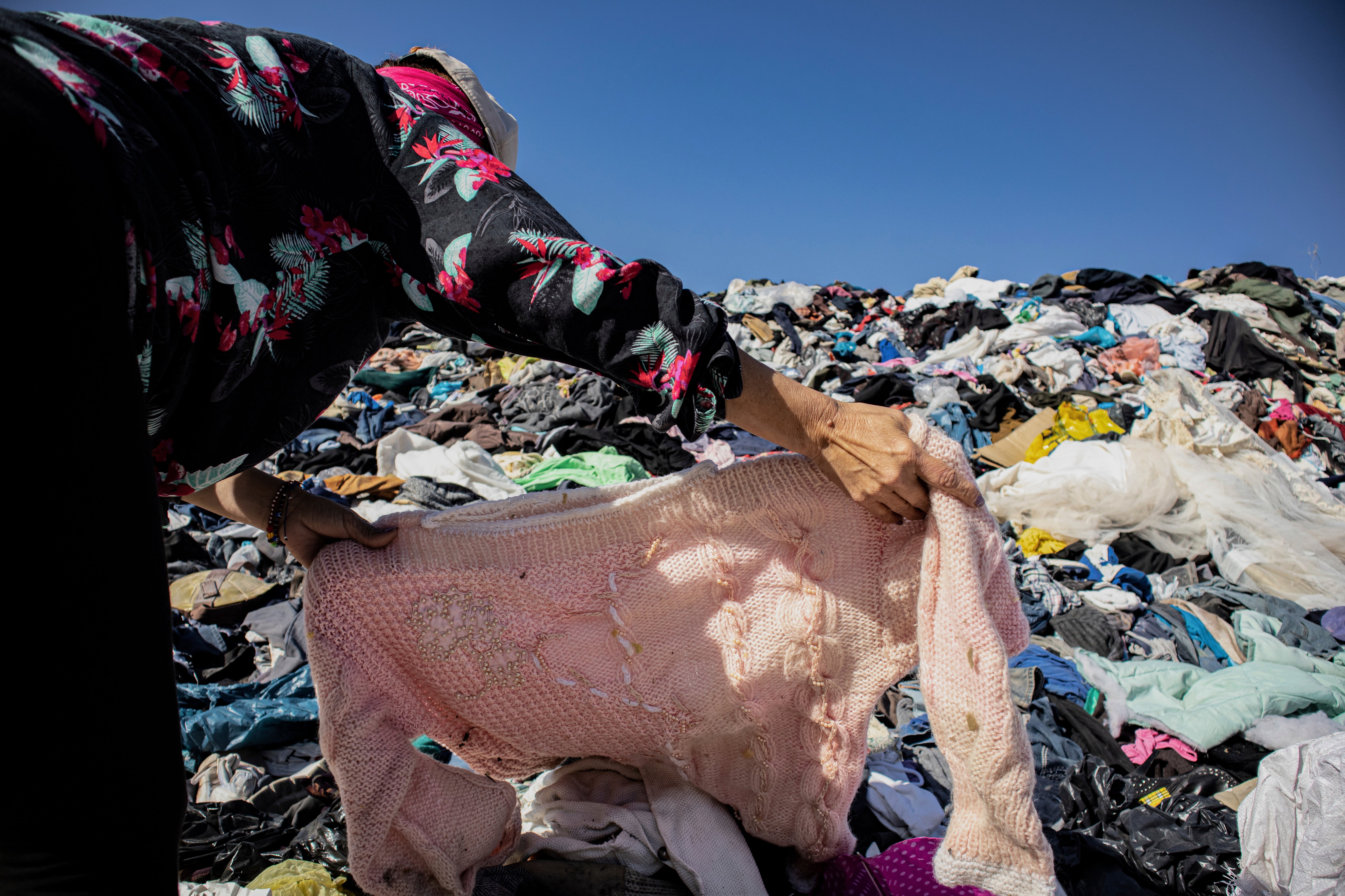 A person searches for clothing in a pile of discarded garments in the Atacama Desert.  (Photo: Antonio Cossio, AP)