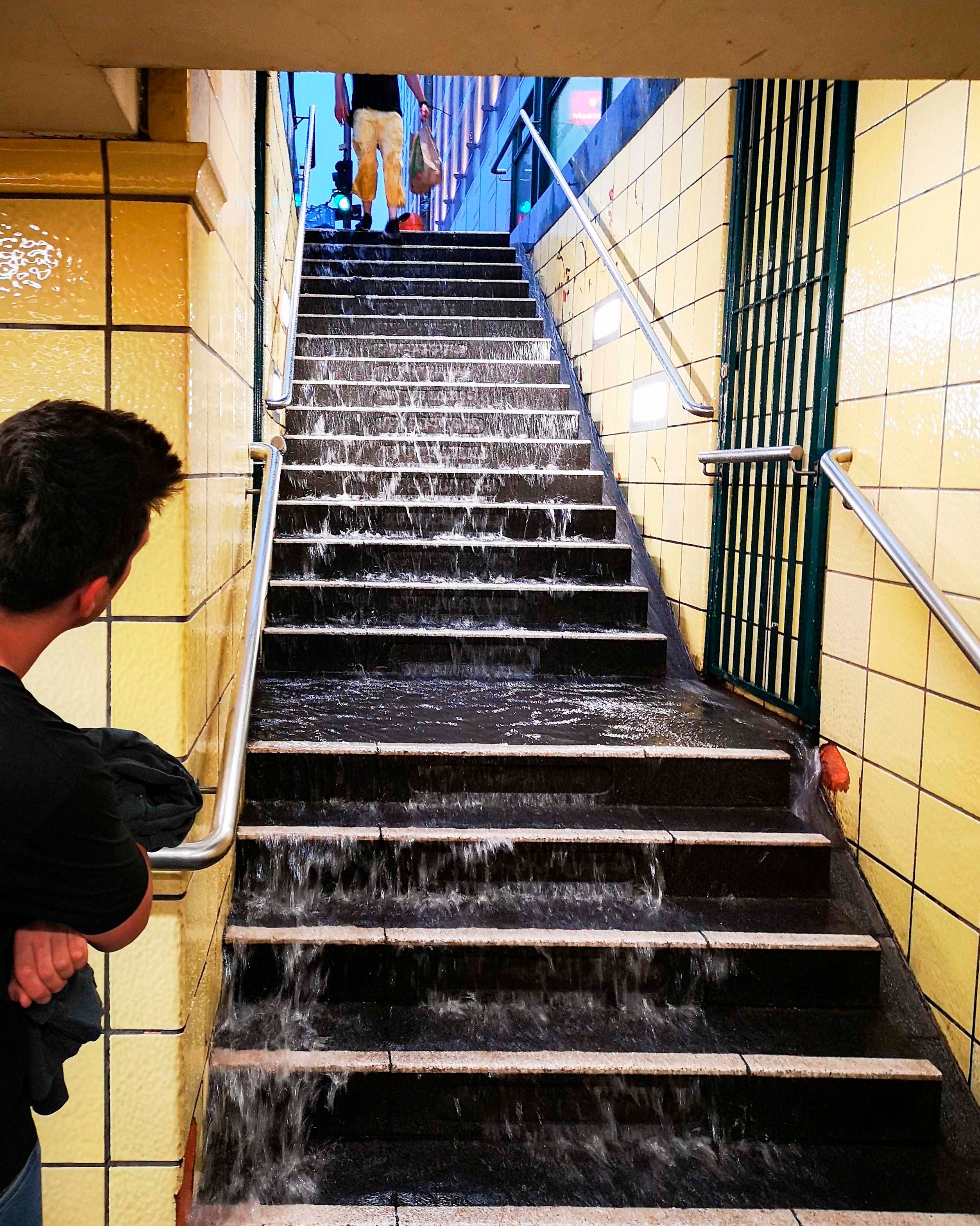 After heavy rainfall, water runs down the steps to the subway at Berlin Friedrichstra'e station. (Photo: Fabian Fuchs, AP)
