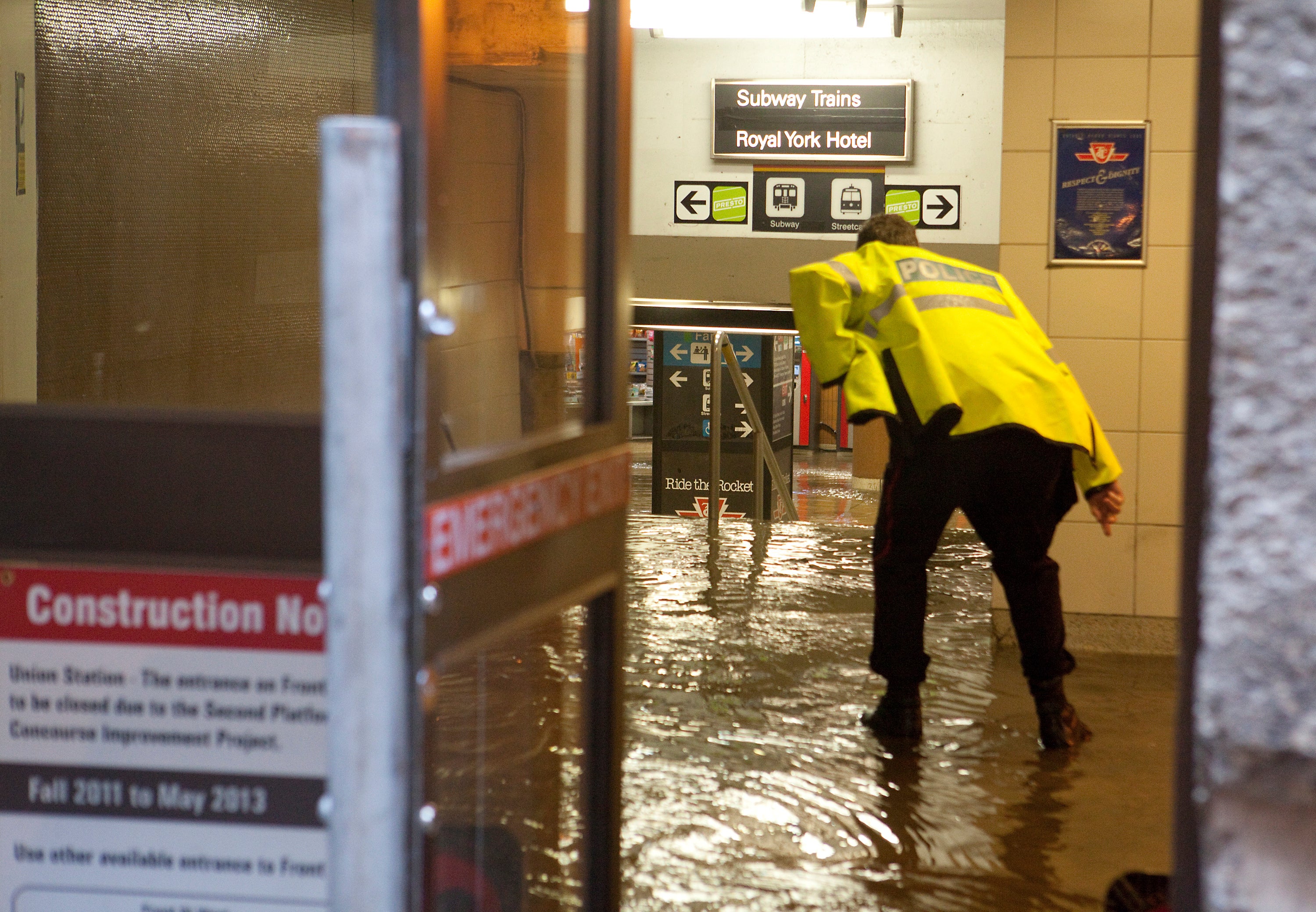 A Toronto police officer leans over to inspect a flooded Union Station Subway in Toronto on Friday, June 1, 2012.  (Photo: Pawel Dwulit/Toronto Star, Getty Images)