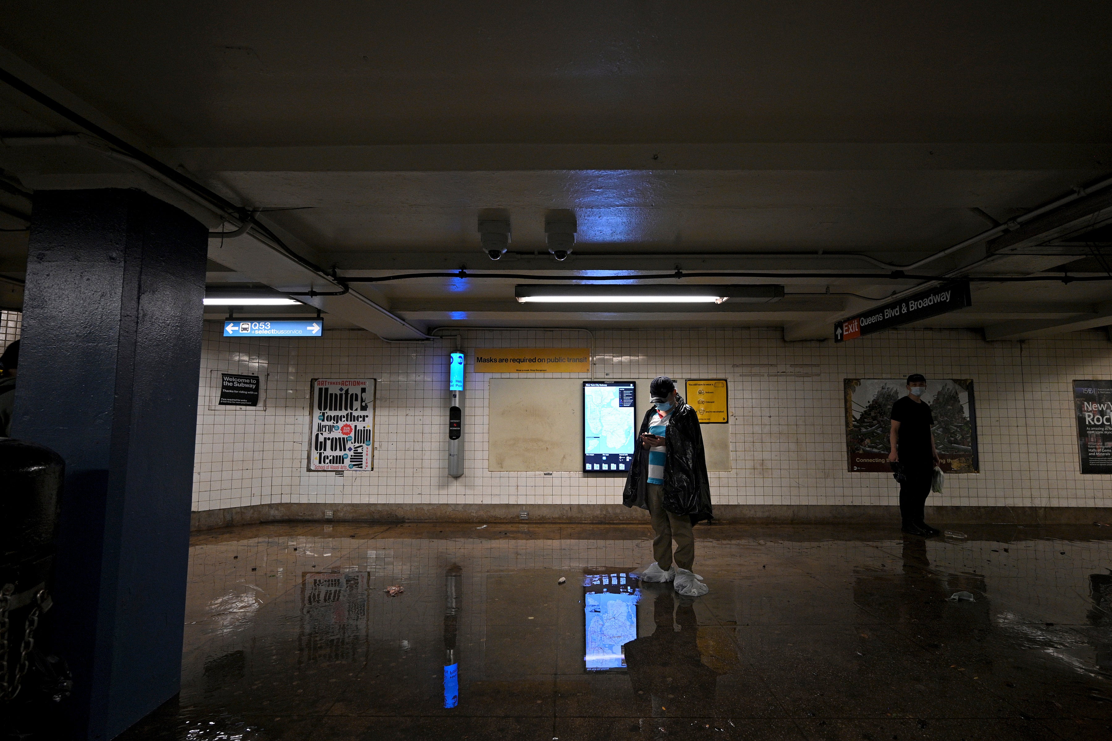 A man wearing plastic bags over his shoes waits for the subway service  to resume as remnants of Hurricane Ida causes flash flooding across the  city, in the New York City borough of Queens, NY, September 1, 2021. (Photo: Anthony Behar/Sipa USA, AP)