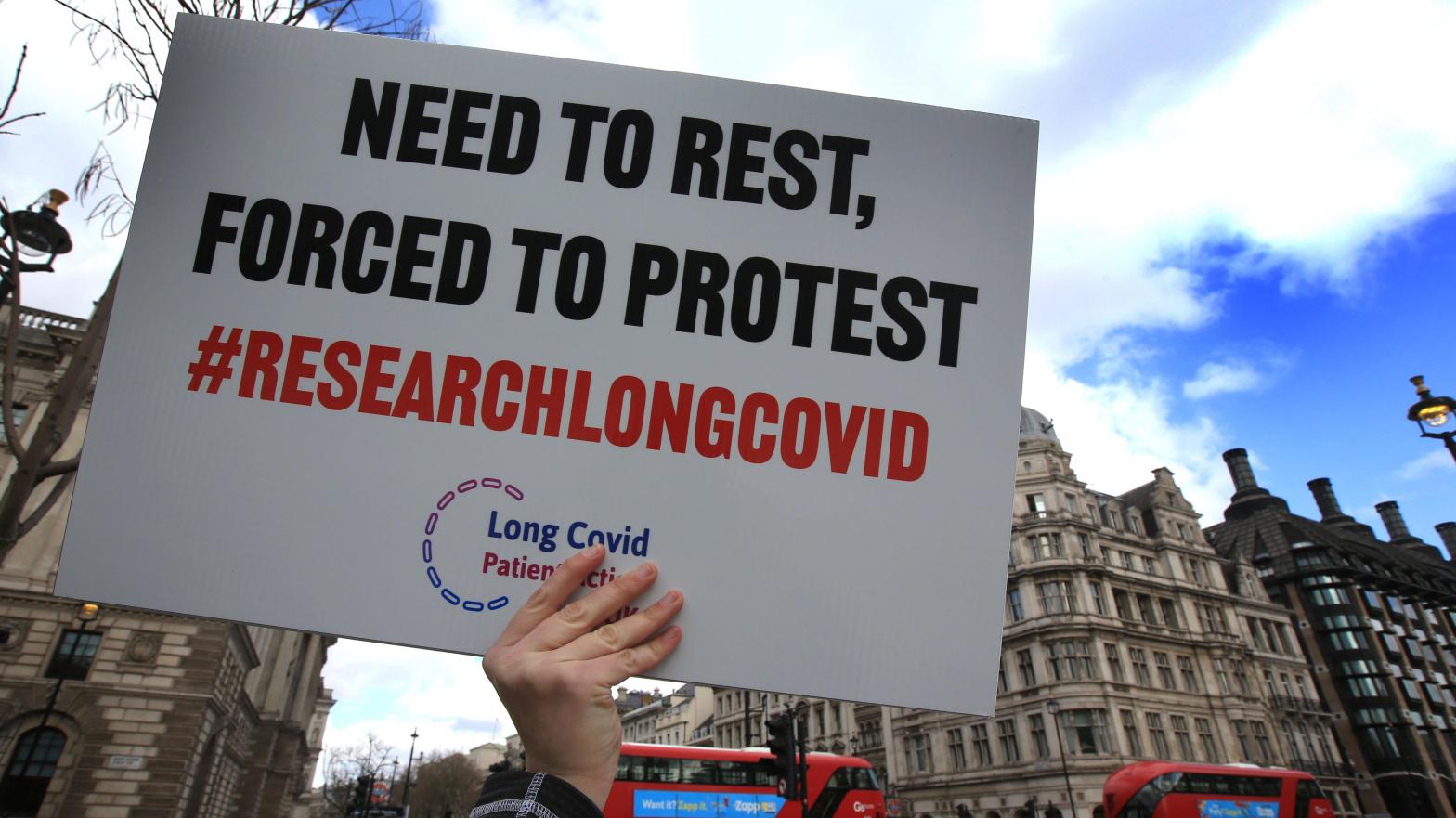 A protester holds up a placard demanding research into long covid during a demonstration in the UK this March. (Photo: Martin Pope/SOPA Images/LightRocket, Getty Images)