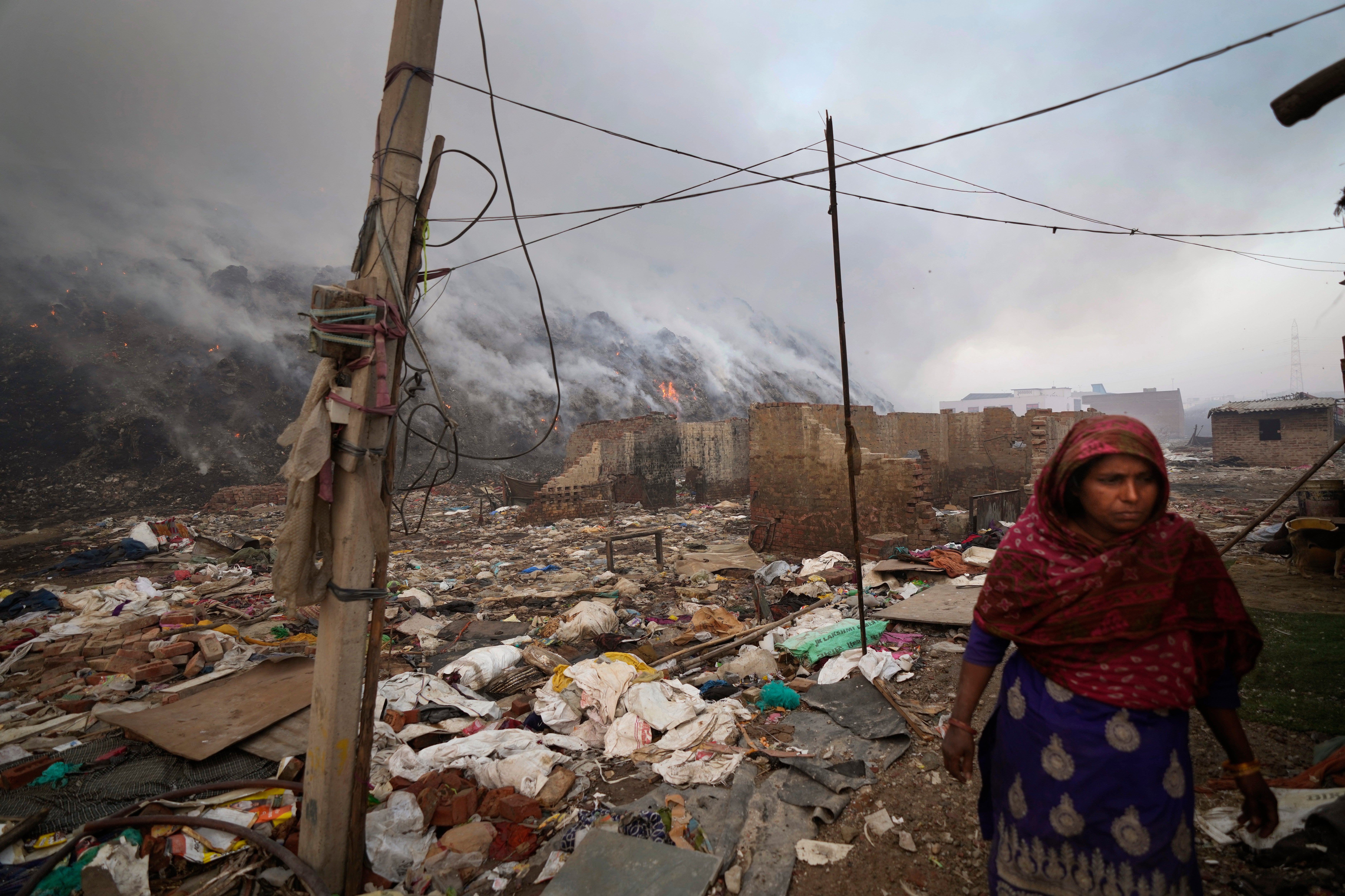 A woman stands near the edge of the landfill. (Photo: Manish Swarup, AP)