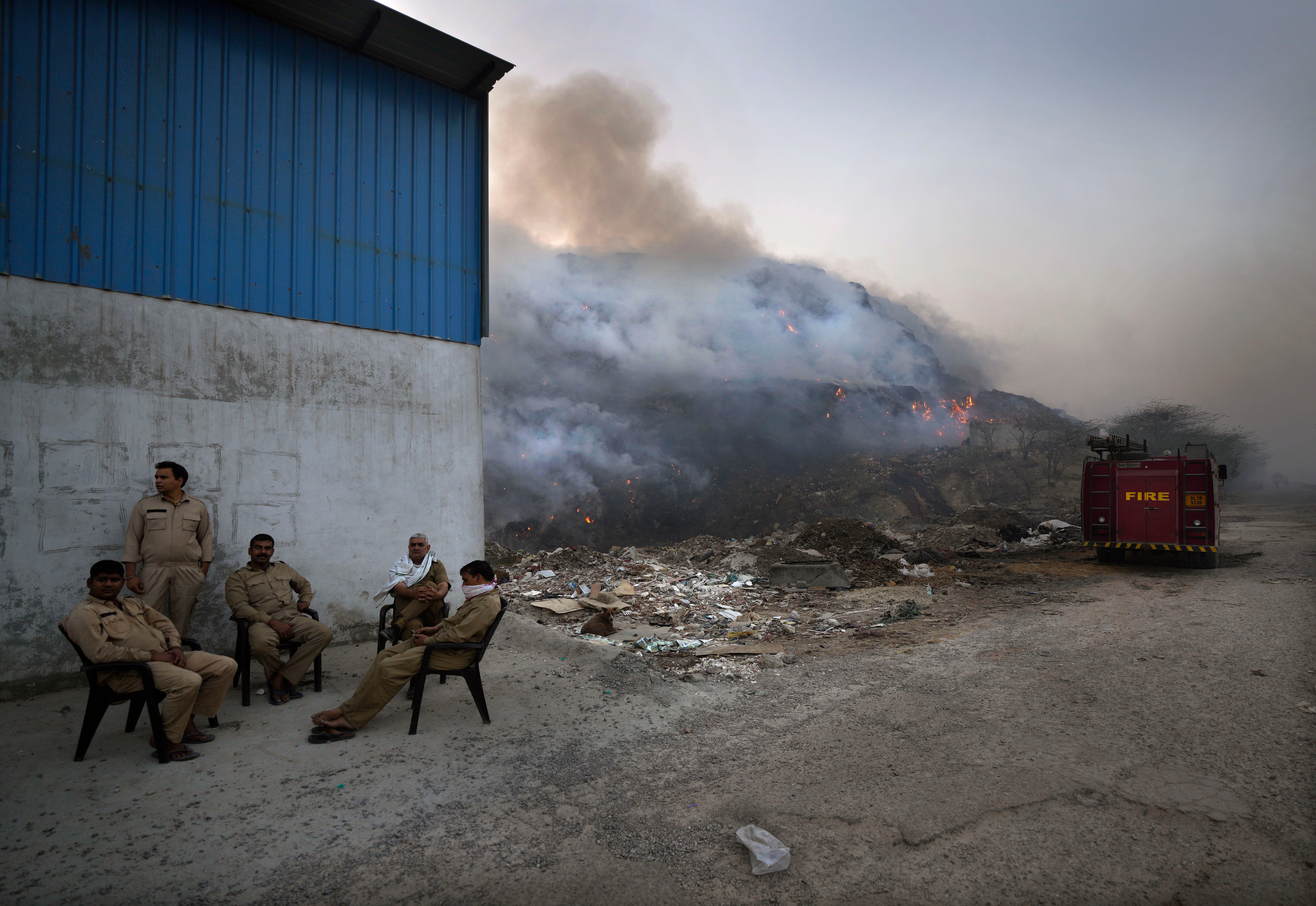 Officials take a break from firefighting. (Photo: Manish Swarup, AP)